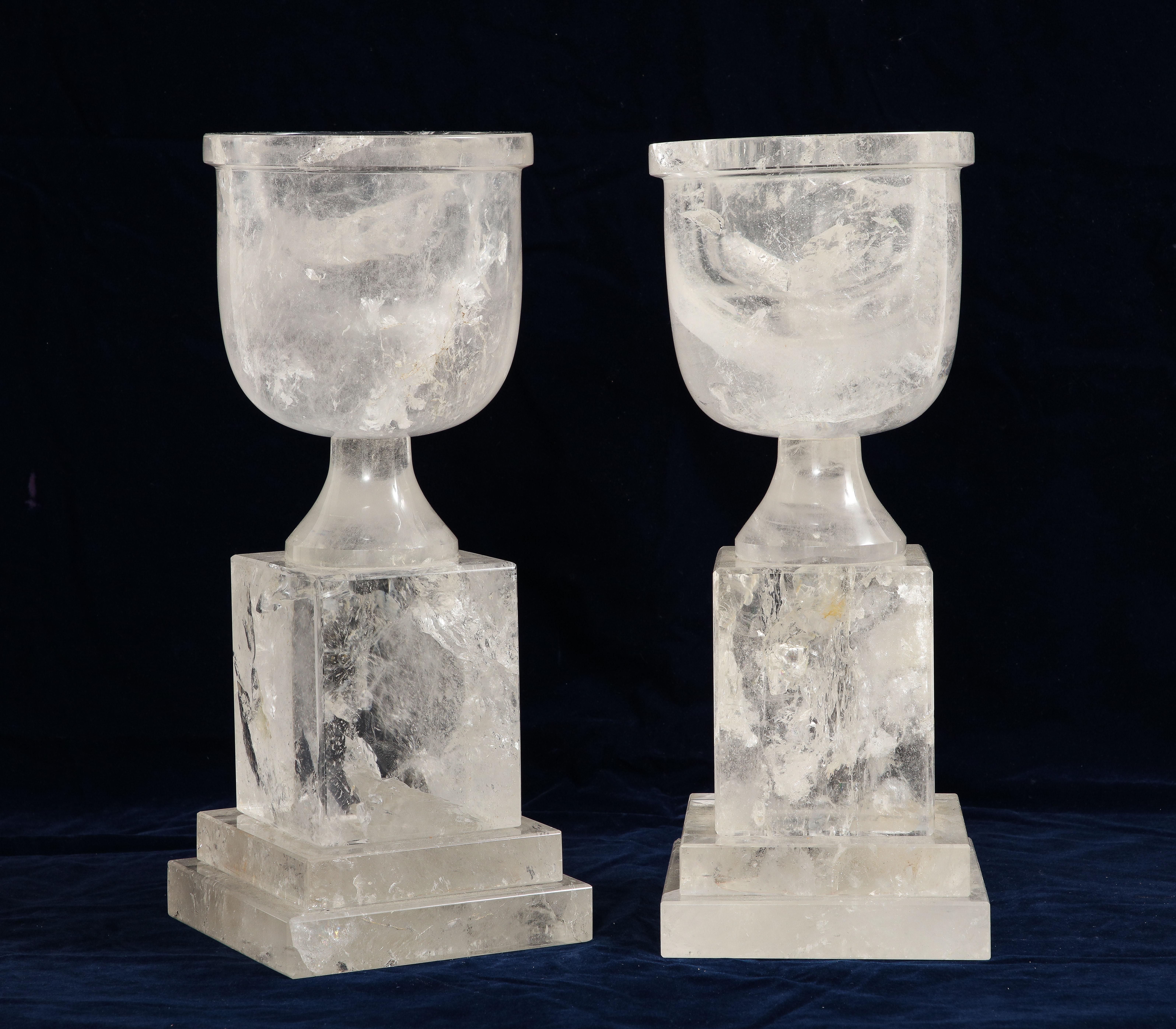 A Pair of Mid-Century Modern French Hand-Carved and Hand-Polished Rock Crystal Vases.  This pair of mid-century modern French vases is a stunning example of hand-carved and hand-polished rock crystal. The vases feature a square step-up base pedestal
