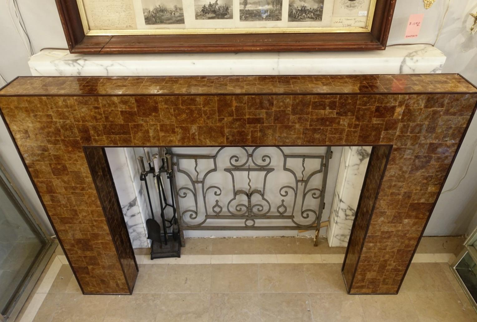 Reclaimed from a prominent New York City Park Avenue apartment, this French earth tone mica fireplace surround has wooden trim along the edges. Signed and made in Paris in 2006 by Ludwig & Dominique Cabinetmakers. The trim around the edges is made
