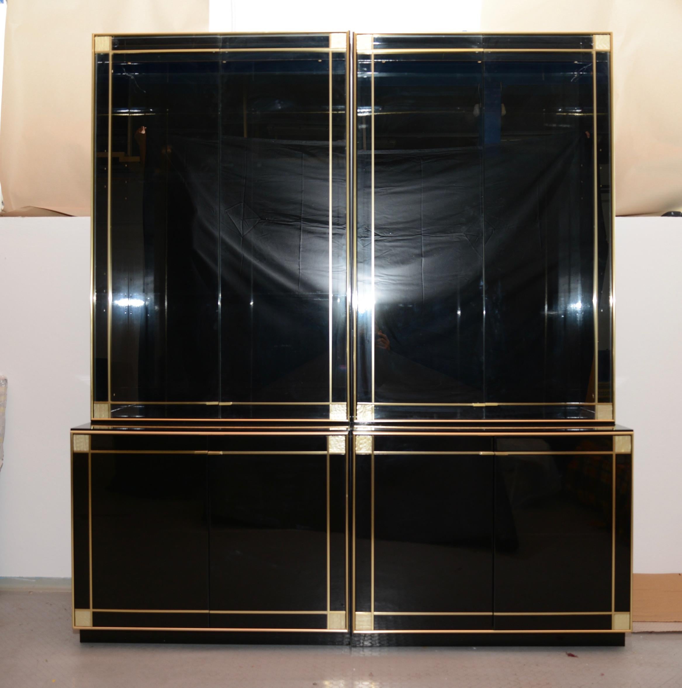 French midcentury lacquered vetrines by Pierre Cardin for Roche Bobois. This pair is made of black lacquer on wood and features gilt brass trim throughout. The strong craftsmanship combined with the elegant lines made this pair a fabulous dining