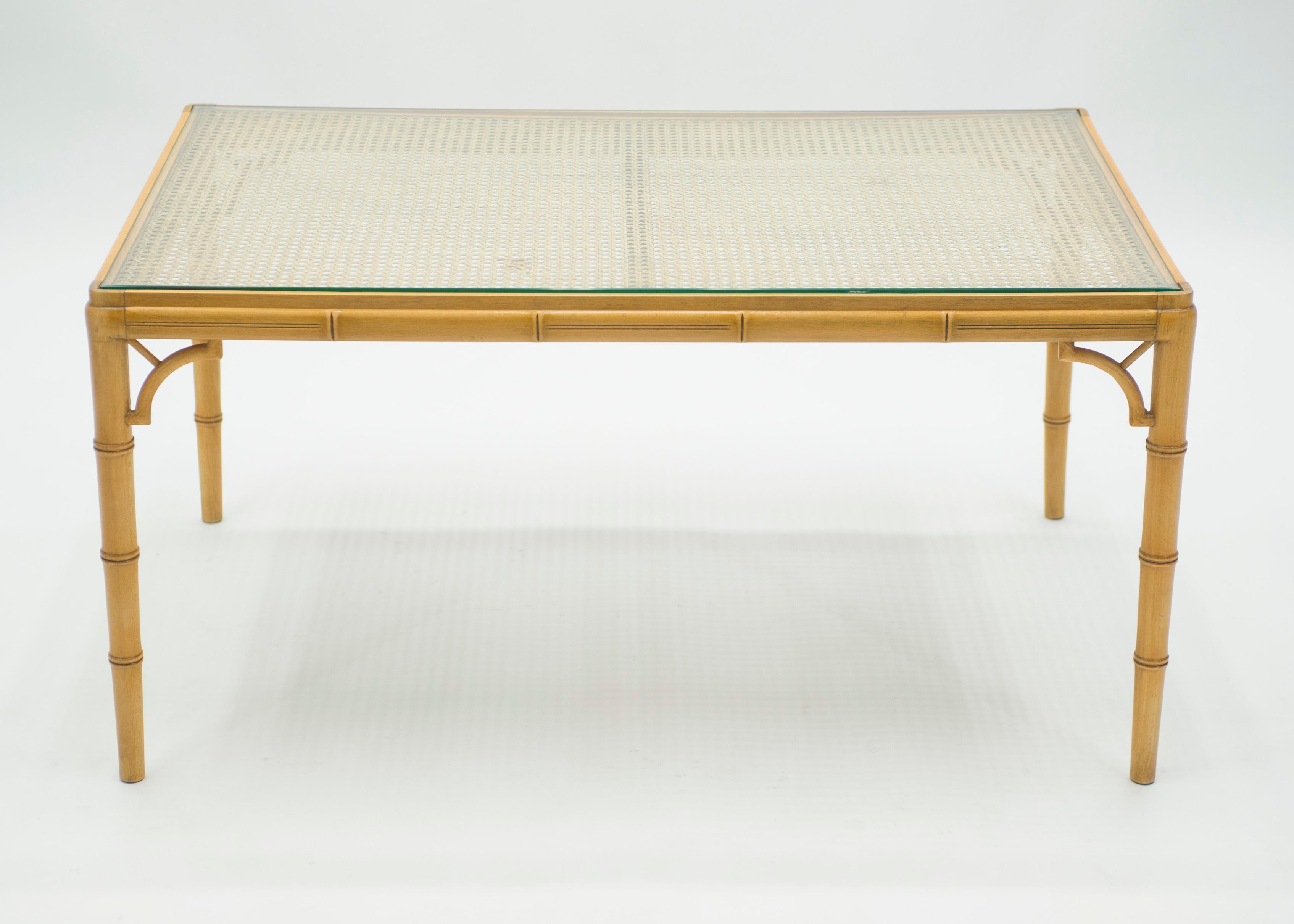 This bamboo coffee table from the Mid-Century Modern French Riviera period is bursting with nostalgia. A light golden bamboo structure, cane top with protective glass would feel right at home in a stylish vacation house by the water. The soothing