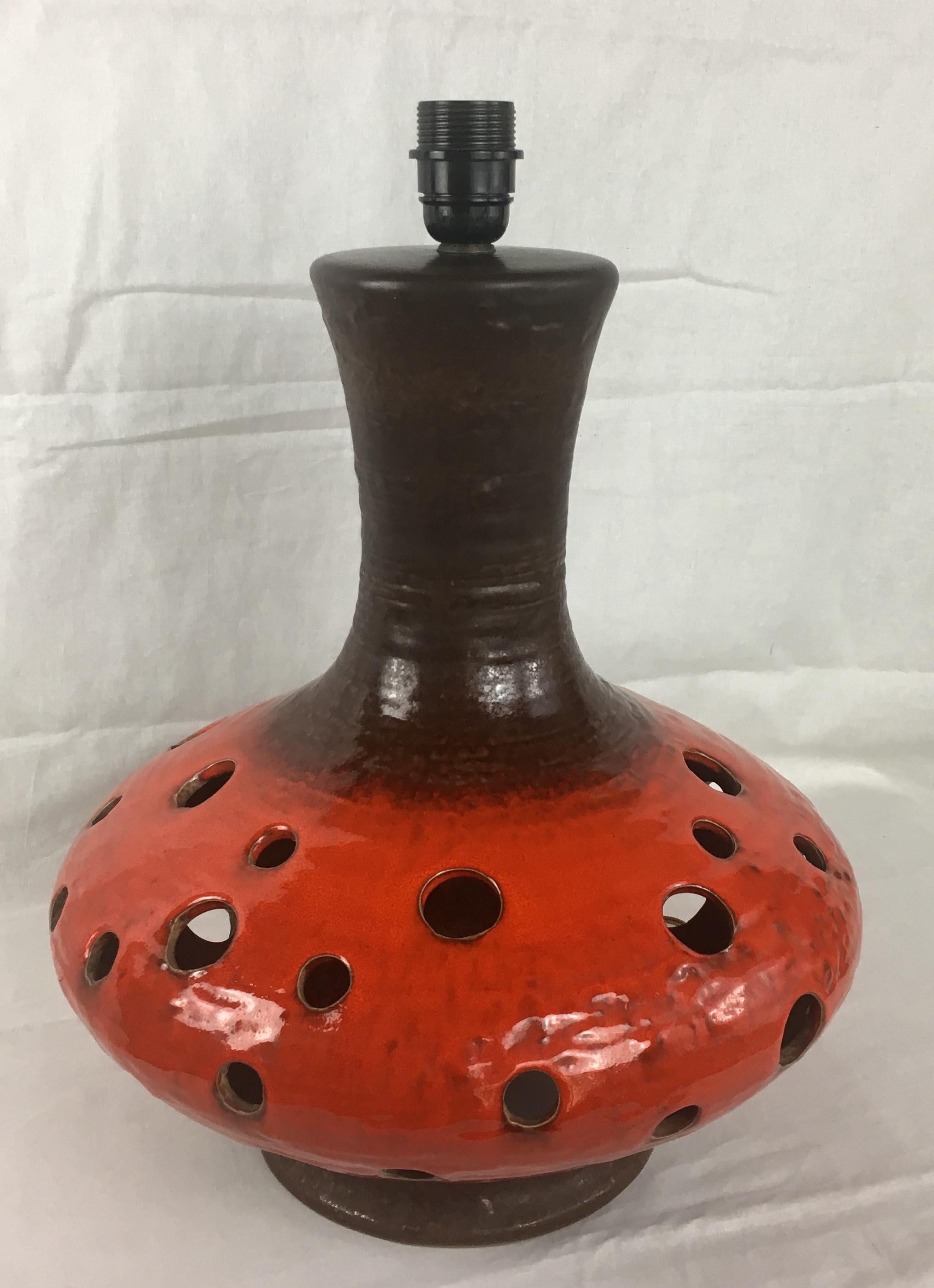 Very decorative and large midcentury table lamp attributed to Georges Pelletier, France made from ceramics and finished in eye catching burnt orange and brown hues. 

The multicolored base combined with the classical shade has many very attractive