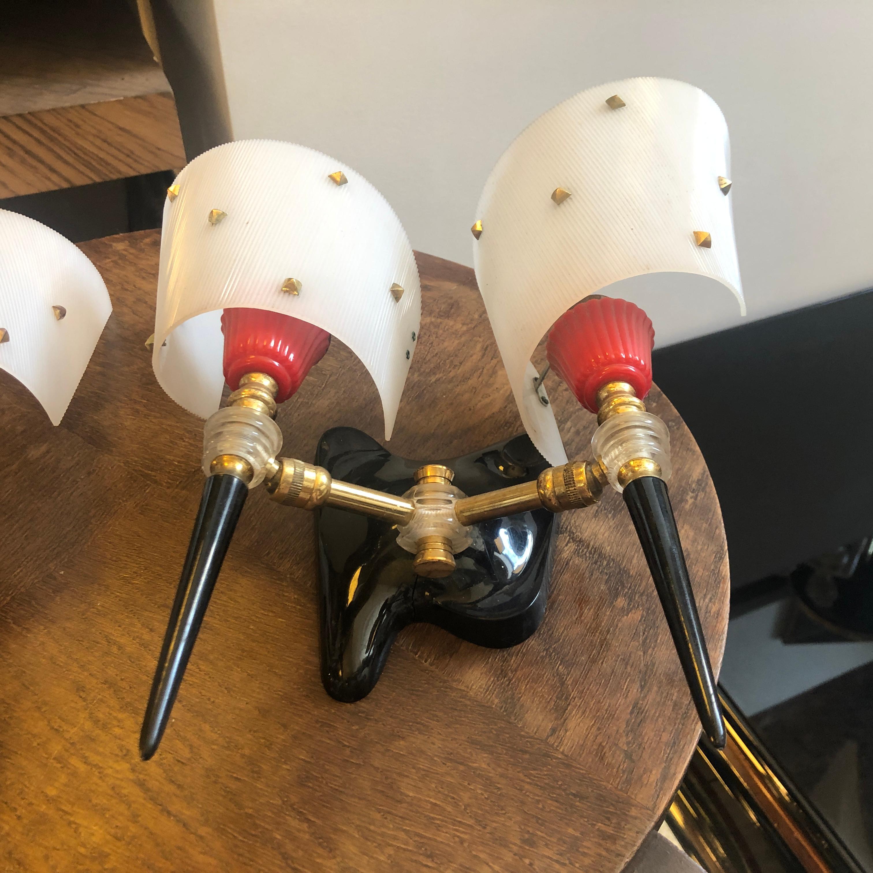 Two plastic and brass red, black and white wall sconces made in France in the 1960s. They are in good conditions and work 110-240 volts and need regular E14 bulbs.