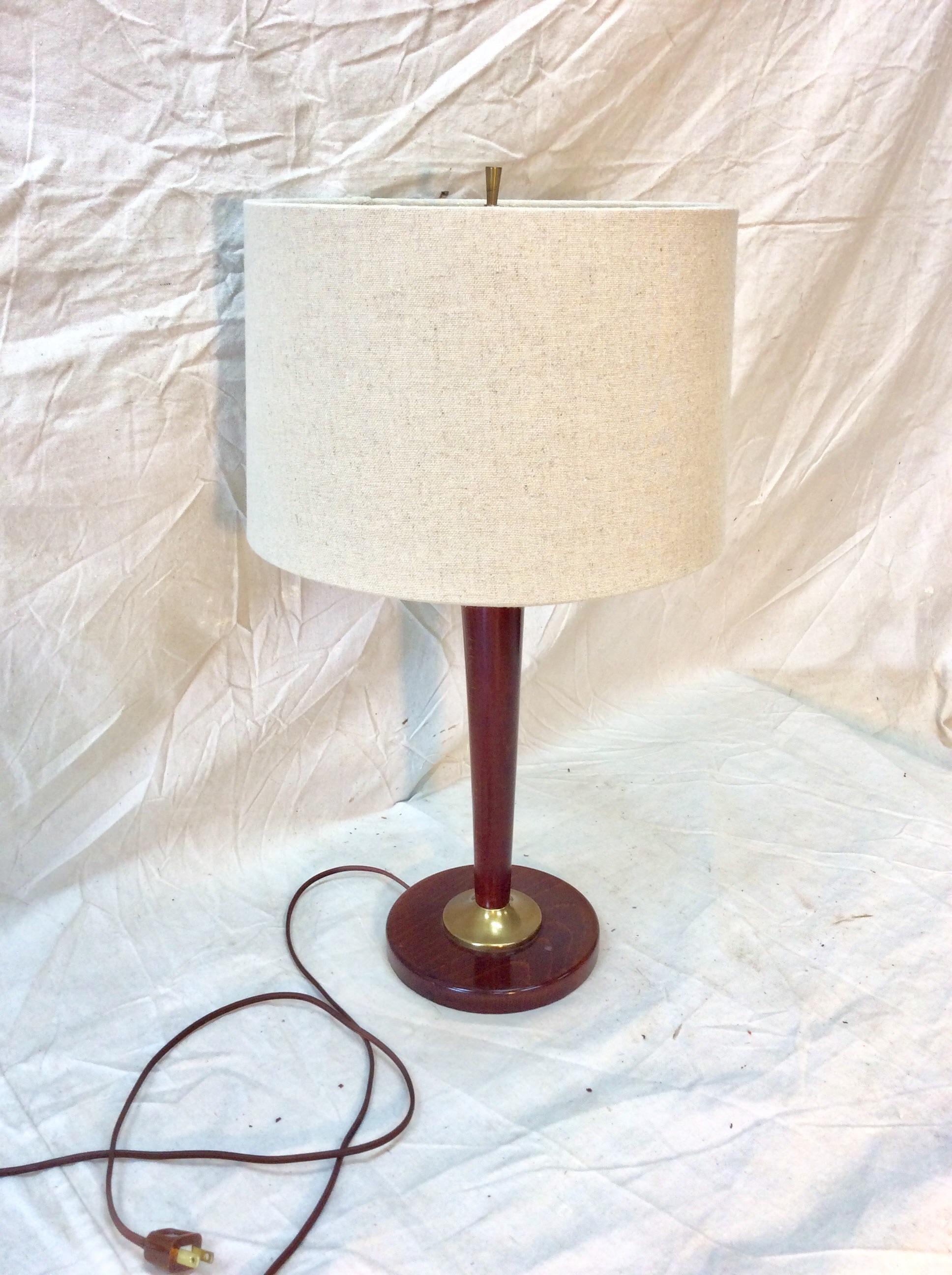 Found in the south of France this Mid-Century Modern French Wood and Brass Lamp is a great size for a table, entry piece or even a desk.  The round base is crafted with a brass center ring which is a beautiful contrast to the smooth wood. The lamp