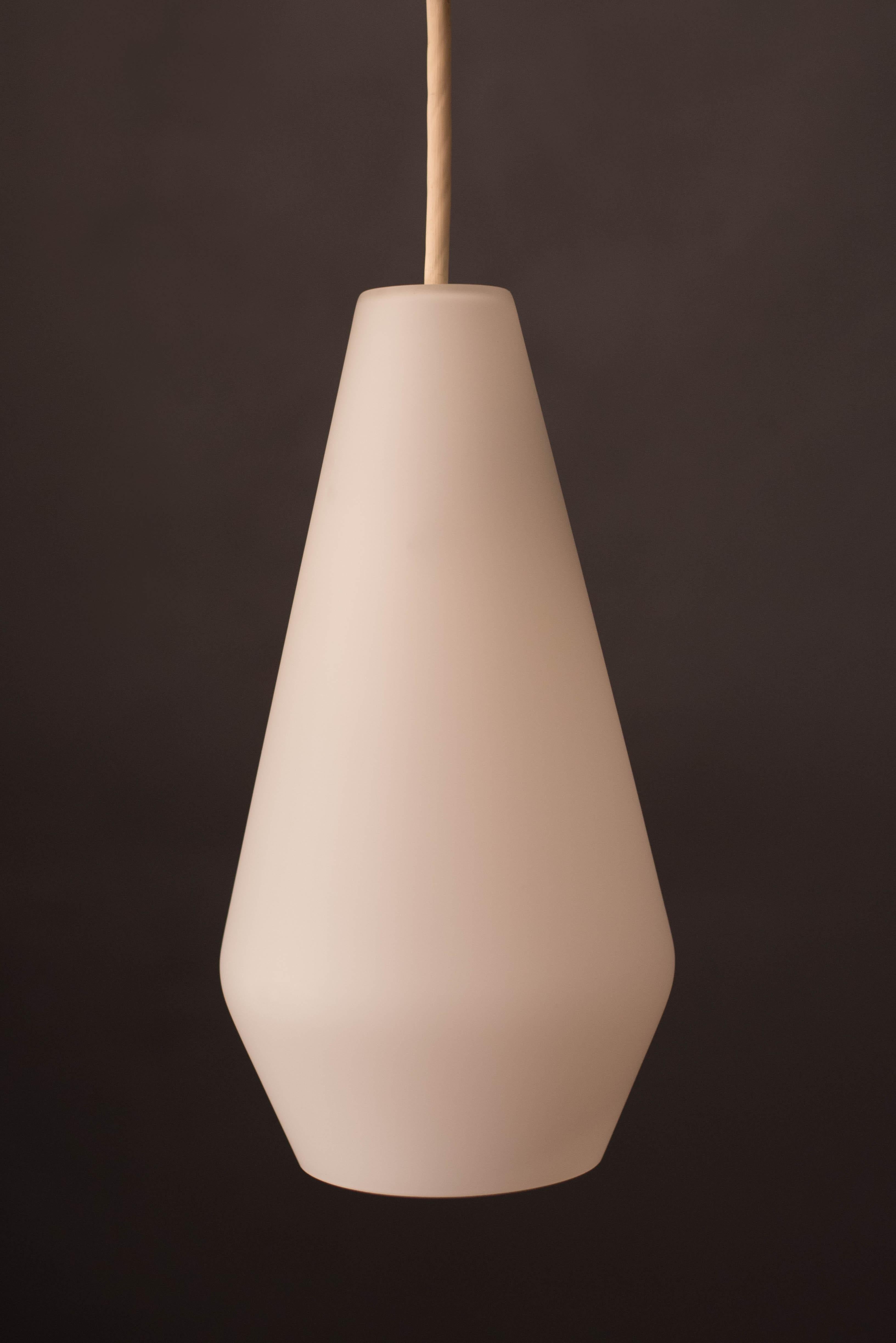 Mid-Century Modern ceiling pendant lamp manufactured by Lightolier circa 1960s. This unique shade is made of frosted glass that emits a glowing light. Perfect to use in the hallway, bedroom, or as lighting in the kitchen. Price is for each, two