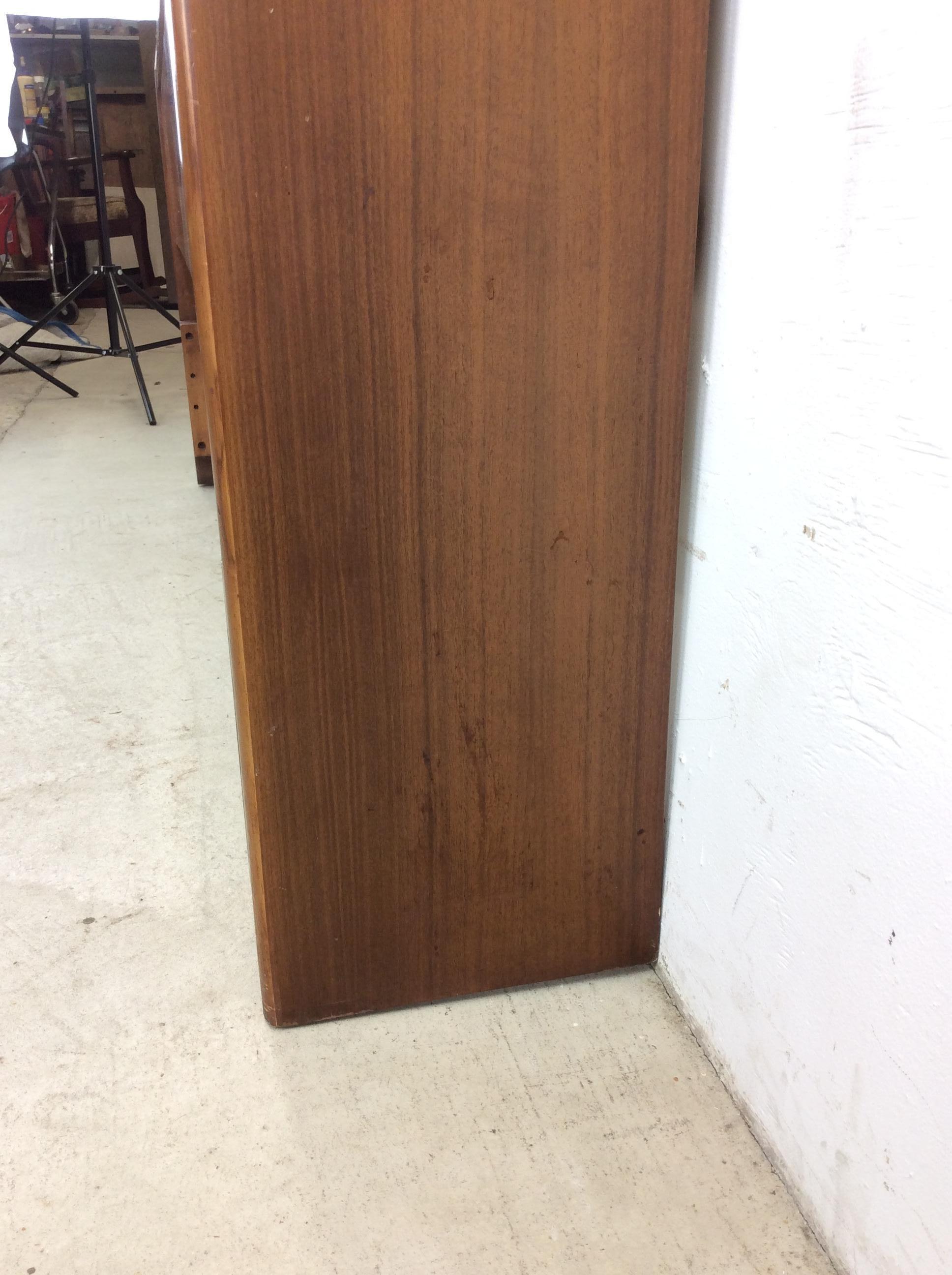 This mid century modern headboard by Kent Coffey features hardwood construction, original walnut finish, two sliding doors offering adjustable configuration of hidden and open storage.   This is a full / double headboard but can be very easily