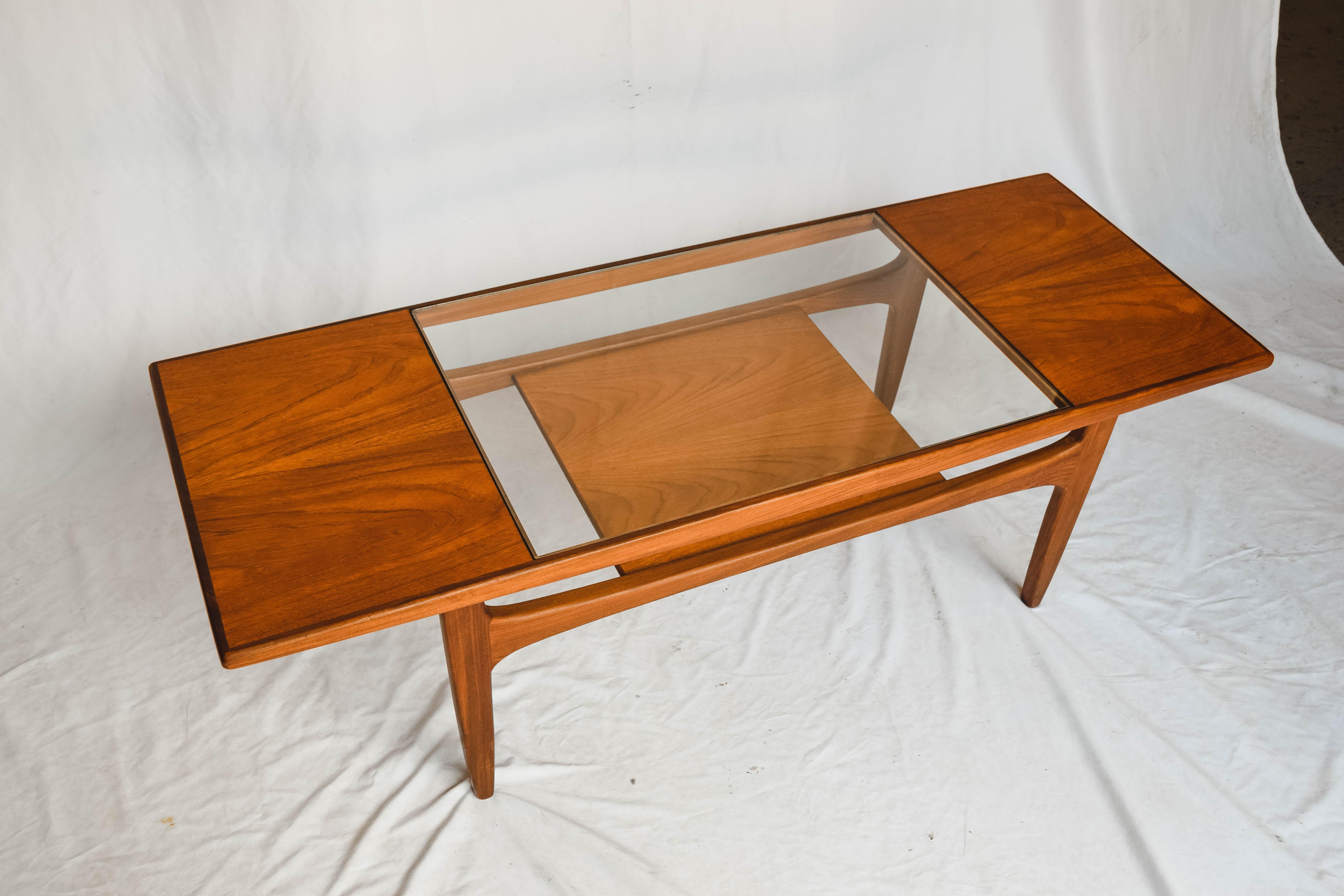 This Mid-Century Modern coffee table was designed by iconic designer V B Wilkins for G Plan in the late 1960s. This coffee table in beautiful teak features a glass top set above a lower magazine shelf. The G Plan Fresco coffee table is an ideal