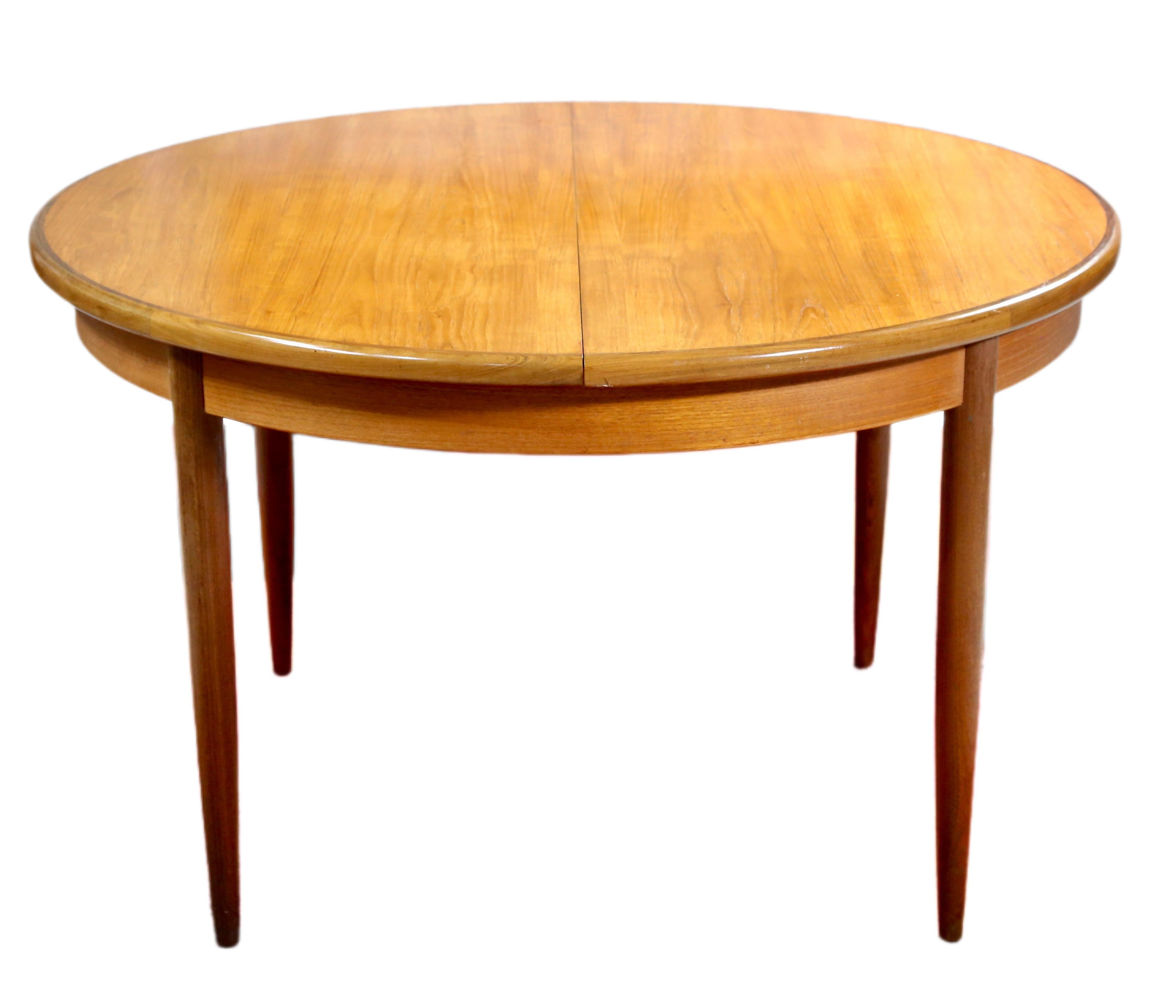 A remarkable Danish style teak dining table designed by VB Wilkins as part of the Fresco range for G Plan. The table features a two panel round top, opening to reveal fold out extension panels, above a round plain frieze, raised on beautifully