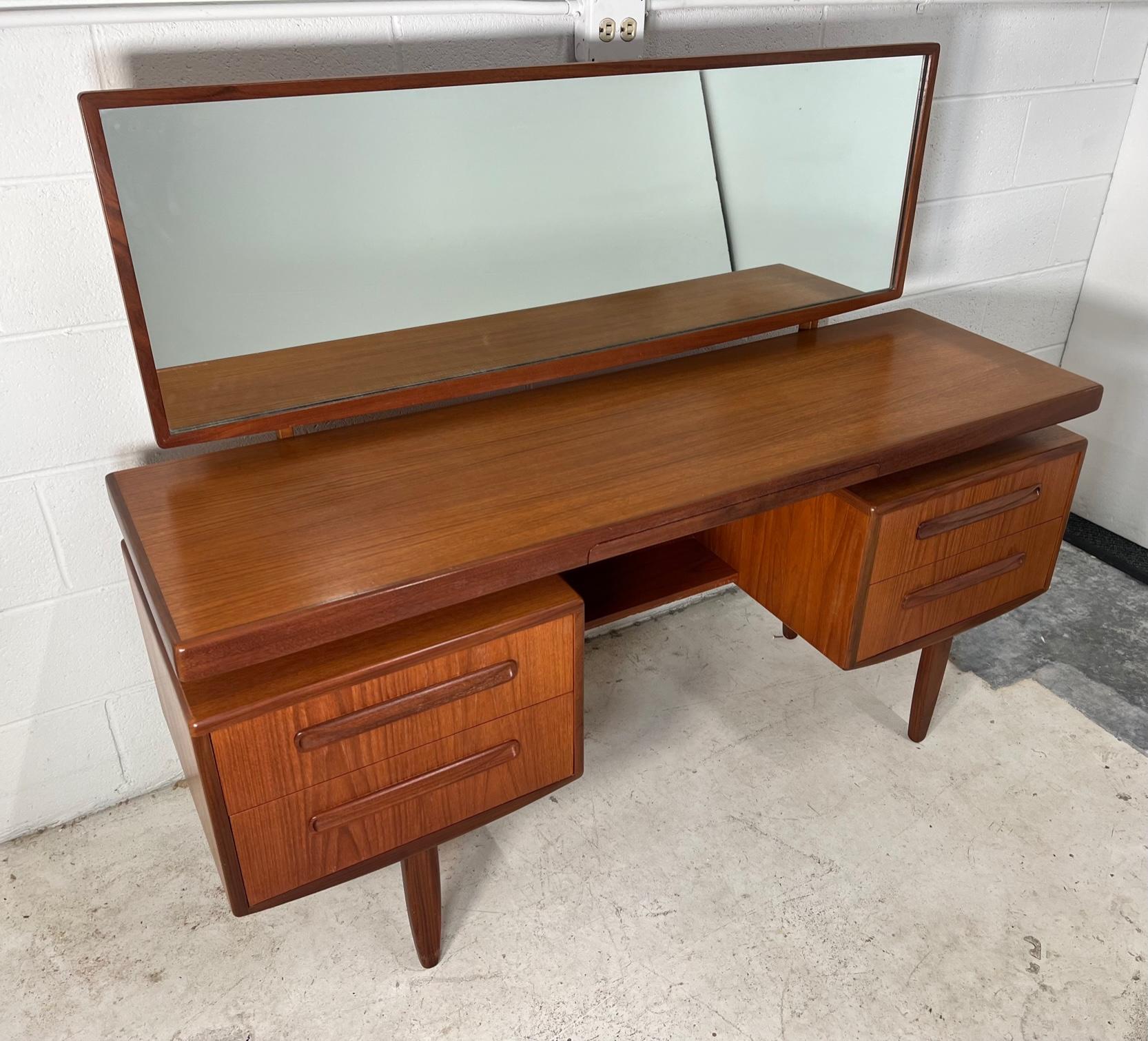 Fantastic mid-century teak vanity with stool. Designed in the 60s by Victor Bramwell Wilkins for G Plan's Fresco Range. Danish Modern in style. Secret drawer has original purple fabric. Gorgeous continuous grain pattern on the front of the drawers.