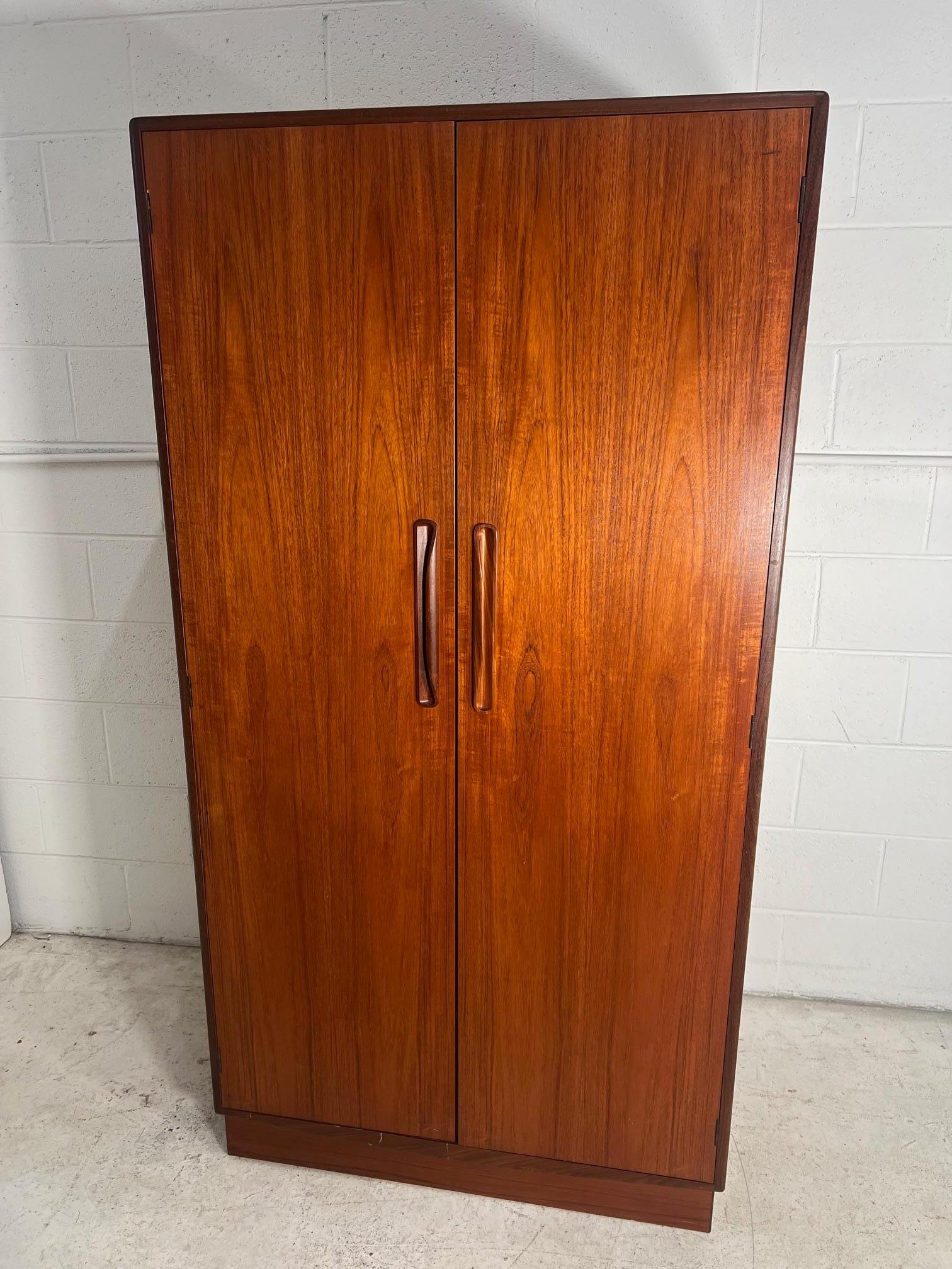Amazing teak wardrobe by G Plan. Designed in the 1960s by Victor Bramwell Wilkins for G Plan's Fresco Range. Danish Modern in style.
Two door wardrobe with half hanging space on the left side and shelves and drawer space on the right. Top drawer