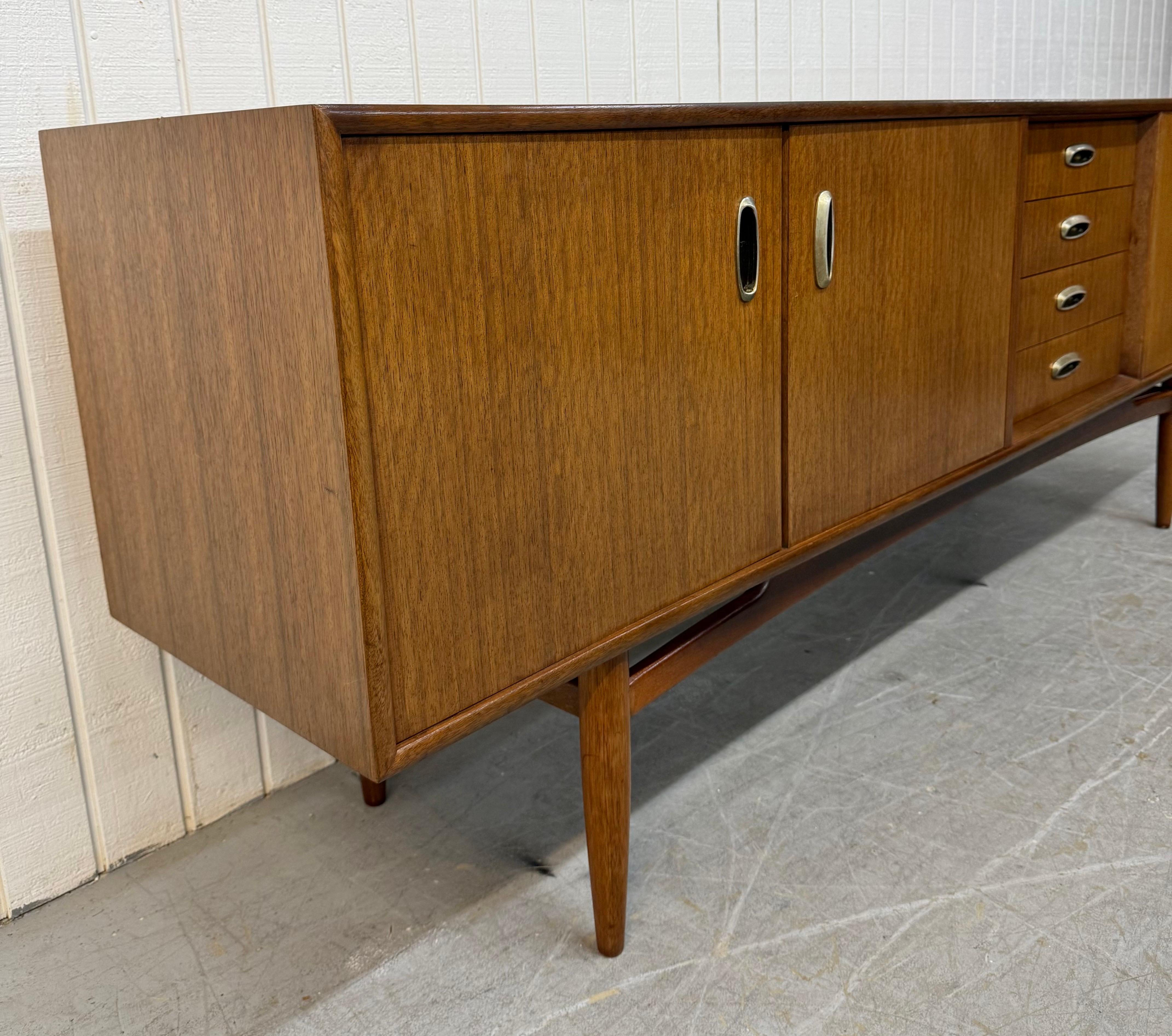 Diese Auflistung ist für eine Mid-Century Modern G-Plan Walnuss Sideboard. Mit einem geradlinigen Design, Schranktüren auf der linken Seite, die sich zu Regalen öffnen lassen, vier Schubladen in der Mitte, einer Klapptür, die sich zu mehr Stauraum