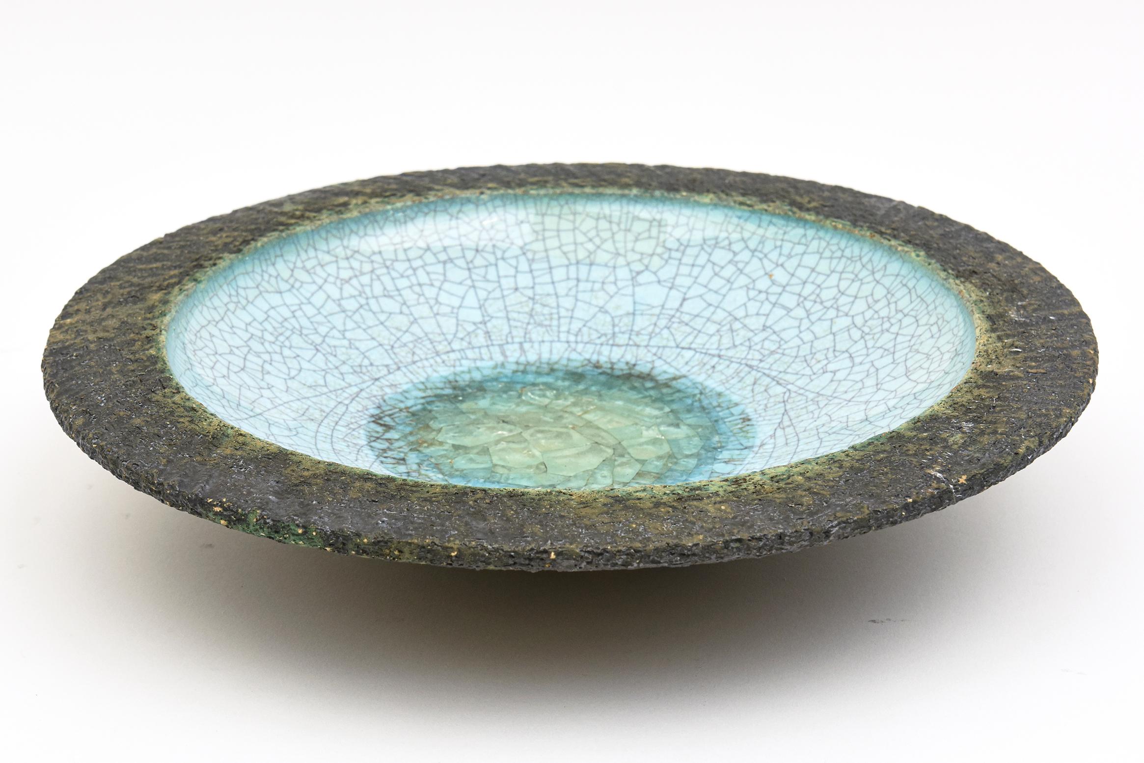 This fabulous Dutch Mid-Century Modern ceramic bowl with crackled glass fritte in the center is a very obscure and rare bowl marked Holland on the bottom. It is very much in the style of Guido Gambone meets Bitossi. The outside ceramic rim is the
