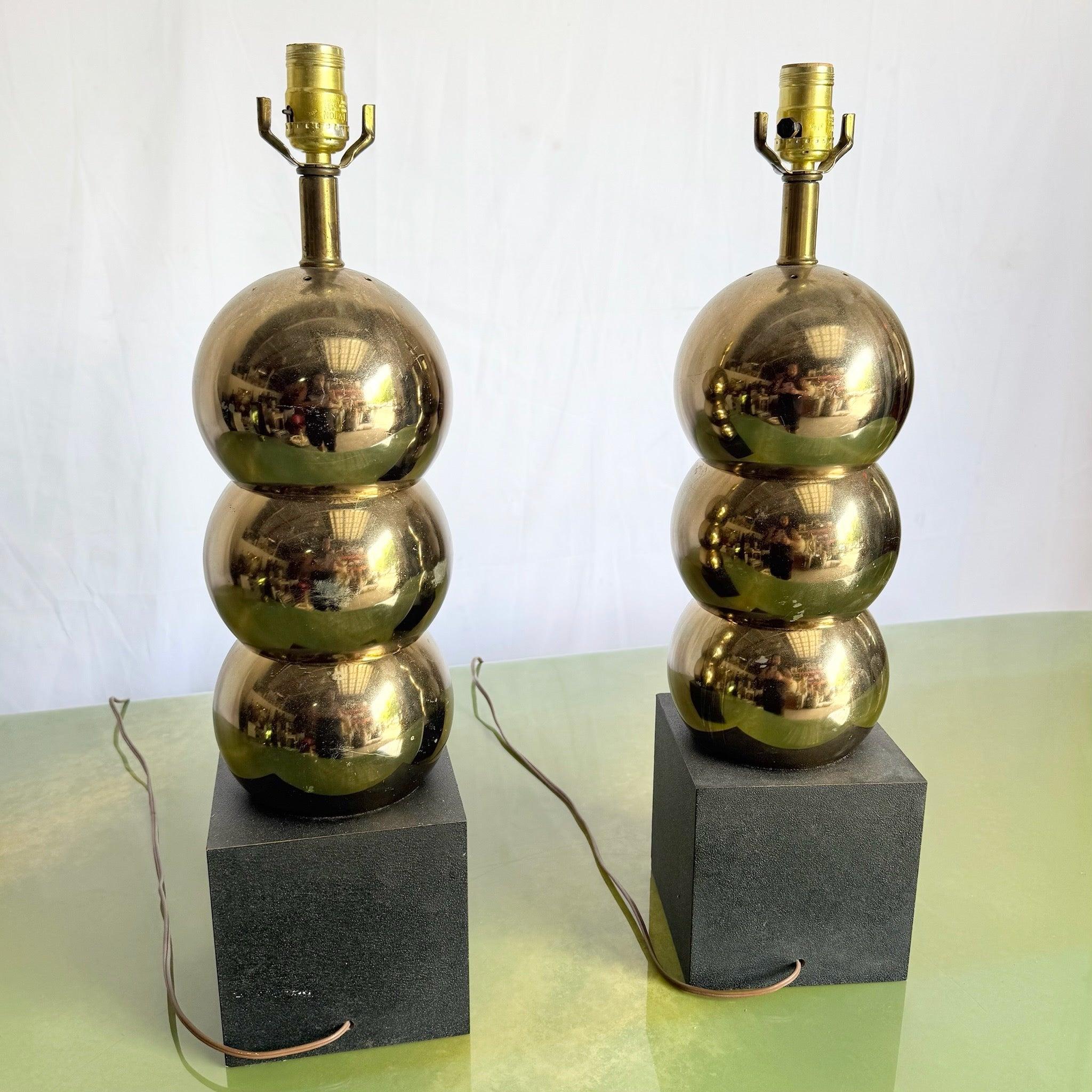 Add sculptural elegance with Mid Century Gold Black Table Lamps—a pair of stacked gold orbs on black cube bases exuding atomic-era geometry.
 

 We sell items as acquired, without restoring or repairing. Vintage pieces may have age-related wear.