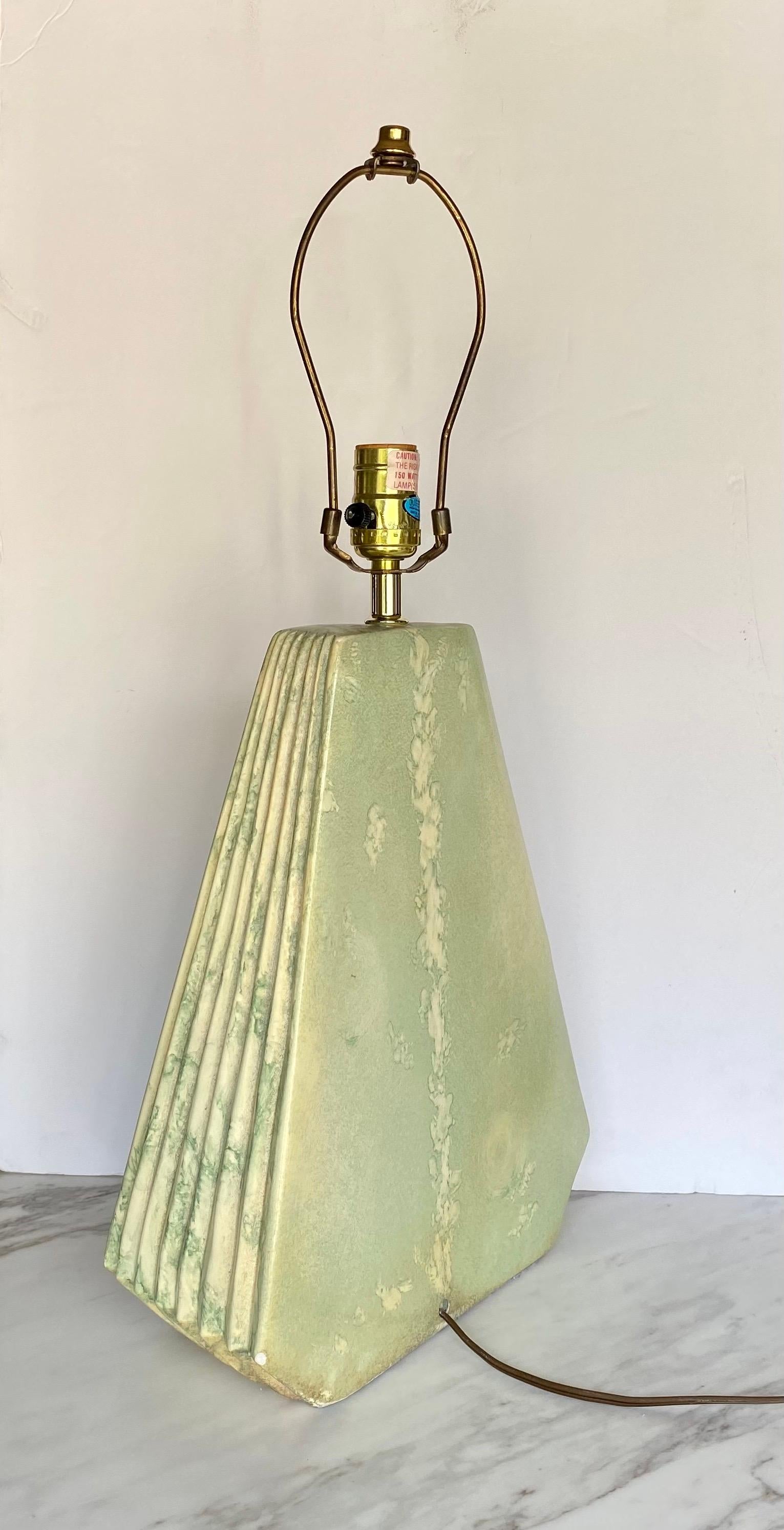 Mid-Century Modern geometric plaster table lamp with ribbed or pleated detailing. This sculptural triangular pyramid form lamp features a beautiful pale green and beige matte glaze. Lamp shade not included. 

Measures: Height to finial: 23.5