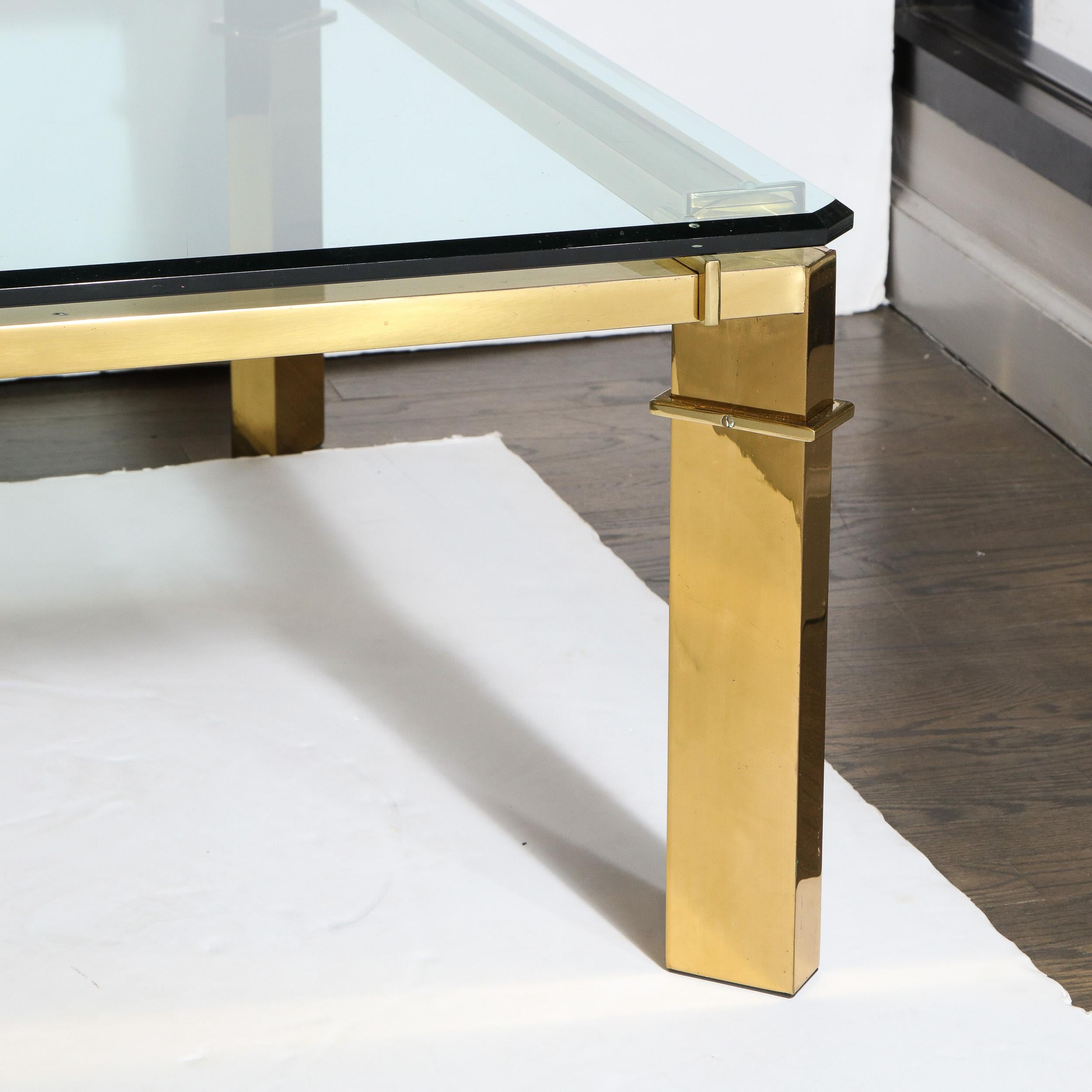 This bold and refined Mid-Century Modern cocktail table was realized in the United States circa 1970. It features volumetric rectangular legs that are positioned at a rotated 45 degree angle in relation to the rectangular form translucent glass top