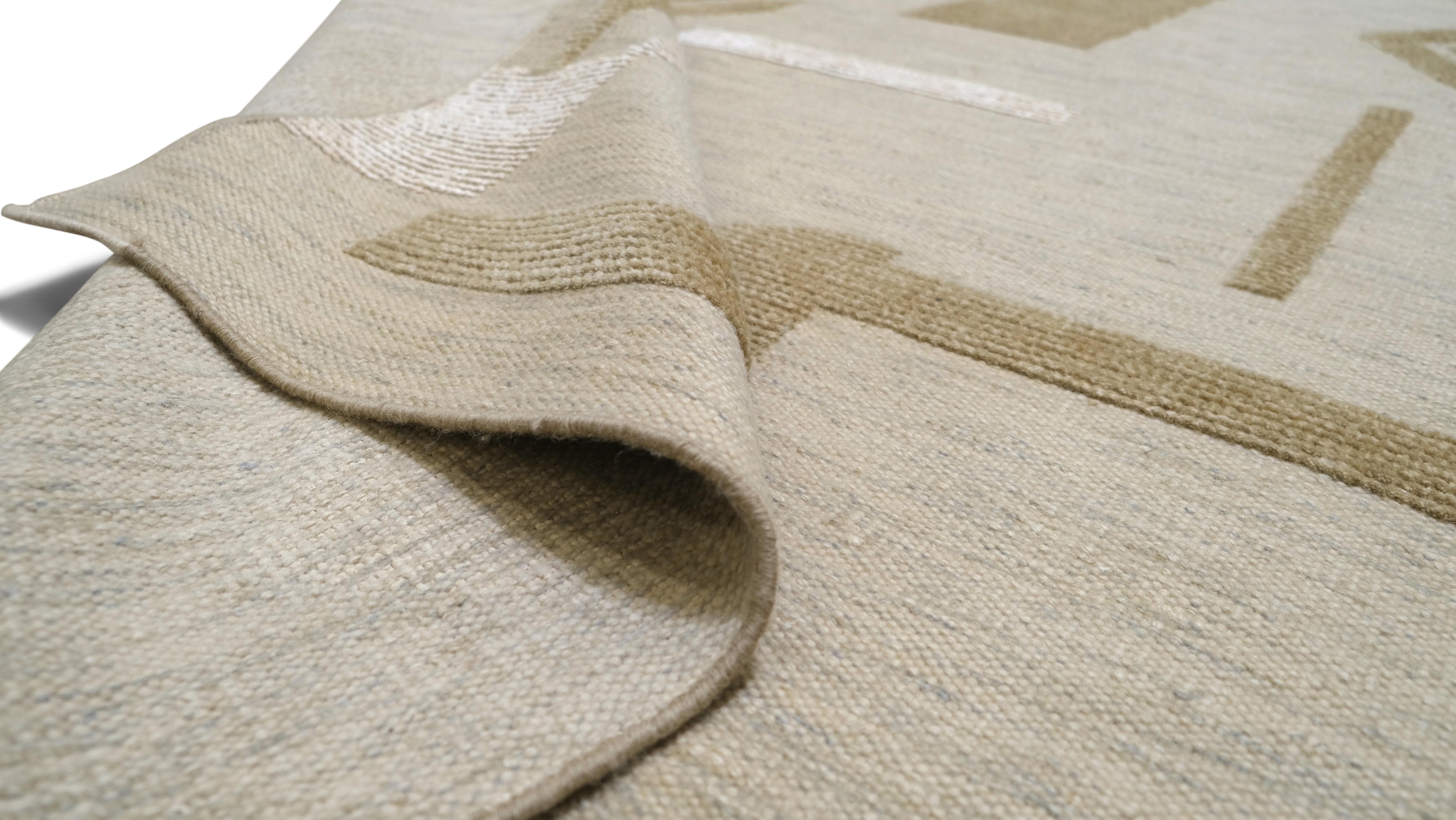 Il présente un motif géométrique abstrait dans des tons neutres de beige, d'or et d'ivoire. L'agencement ludique de triangles, de cercles et de formes angulaires ajoute une touche d'art moderne, faisant de ce tapis une pièce remarquable pour les