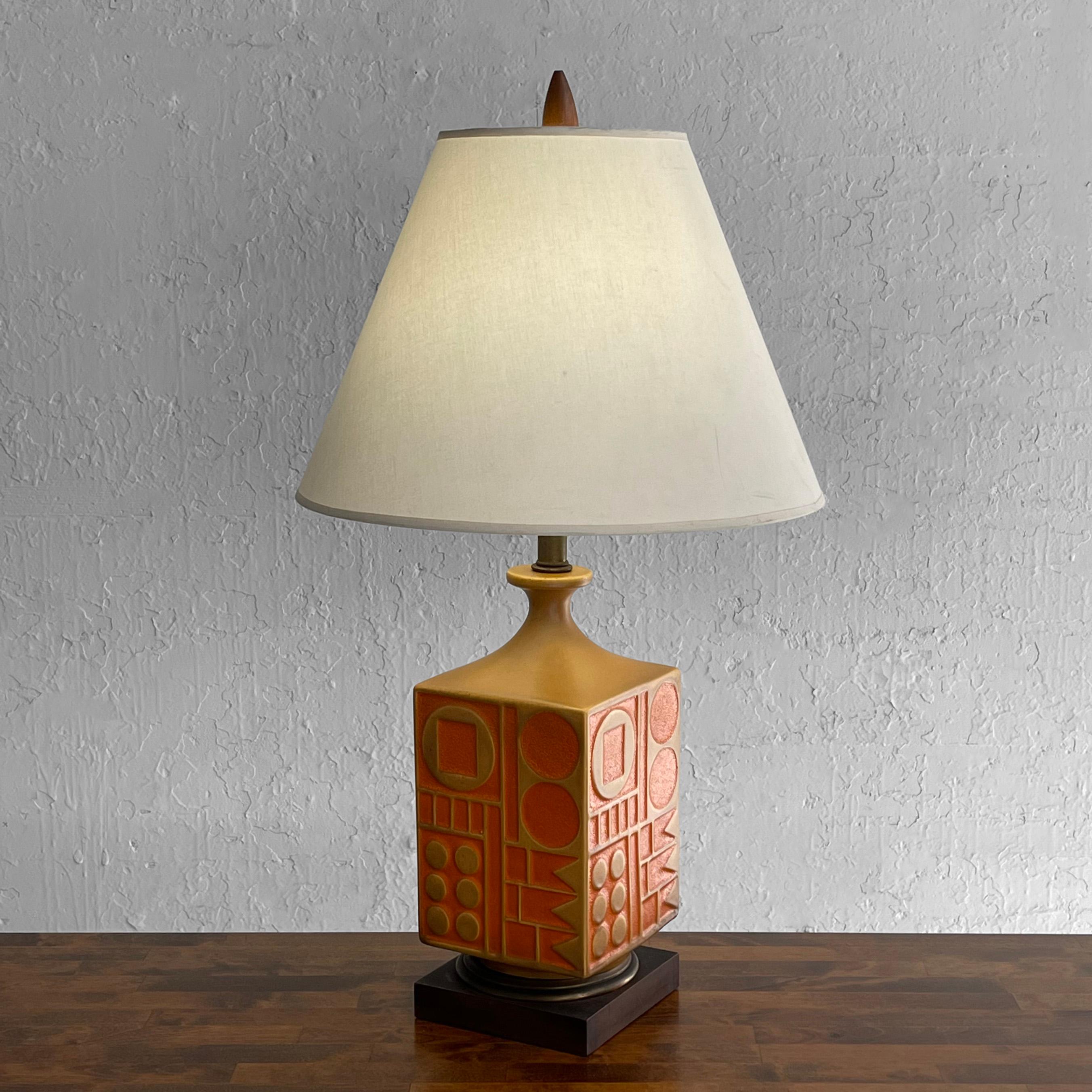 Bold, Mid-Century Modern, art pottery, table lamp by Westwood Studios, attributed to designer Tony Paul features a striking, orange and tan ceramic base with tribal, geometric designs atop a brass ring on painted wood platform with matching finial.