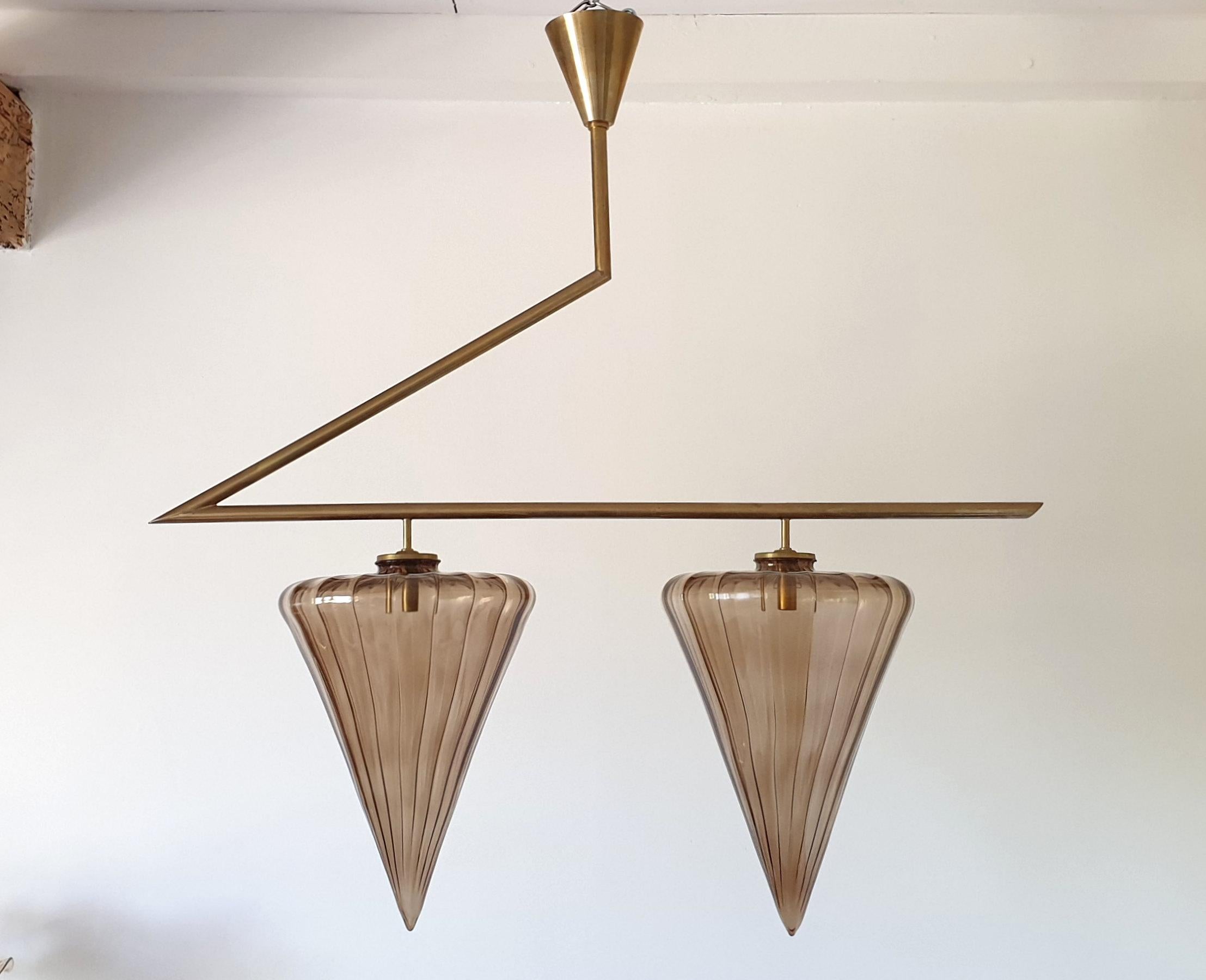 Large Mid-Century Modern chandelier, with a geometrical design, attributed to Seguso, Italy, 1970s.
The chandelier is made of polished brass, and two Murano glass taupe shades, nesting one light each.
The vintage chandelier has been rewired for the