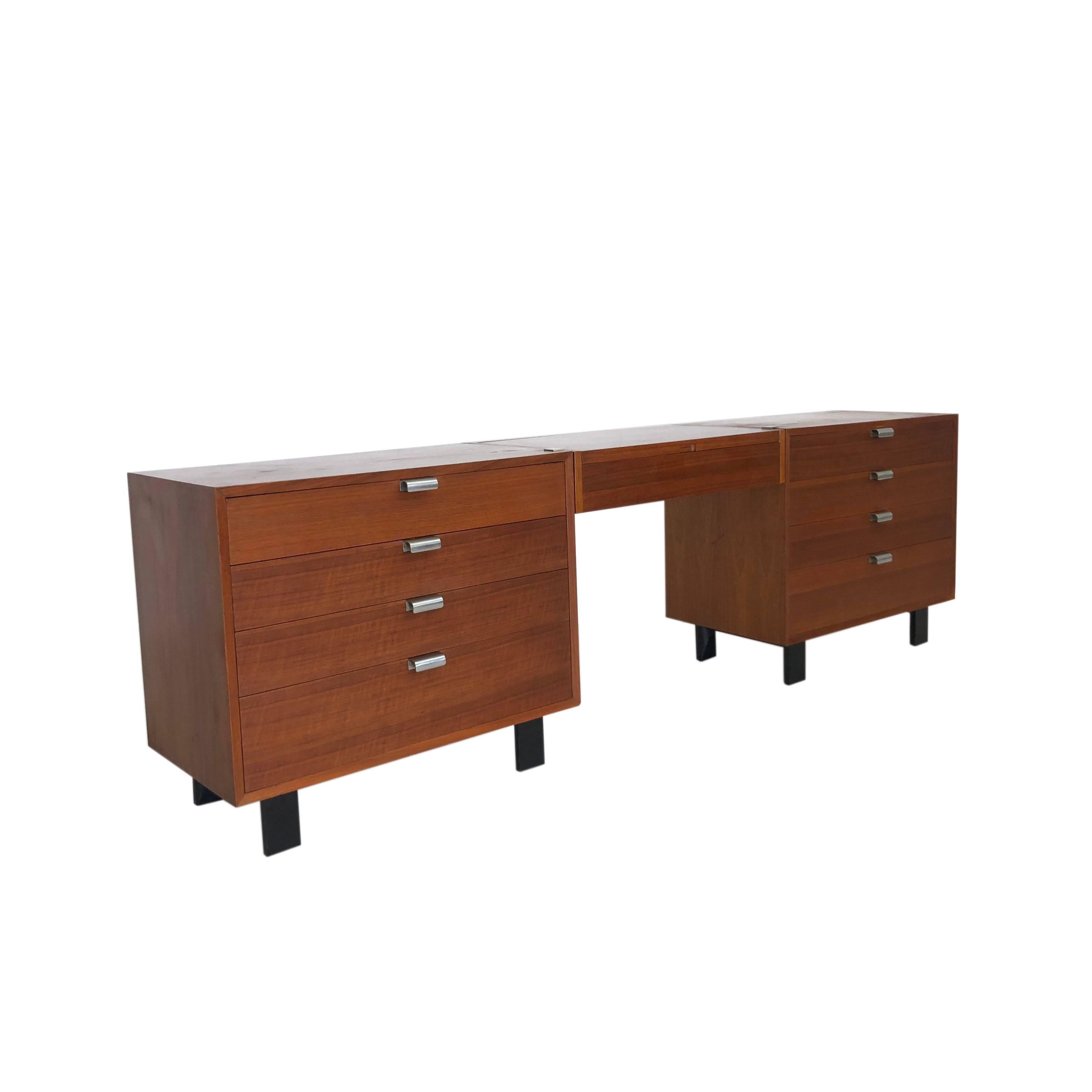 Mid-Century Modern dresserpart of the basic storage components that George Nelson designed for Herman Miller in 1952, this extraordinary set comprises two dressers with black legs in a warm walnut on either side of a suspended vanity.

Each