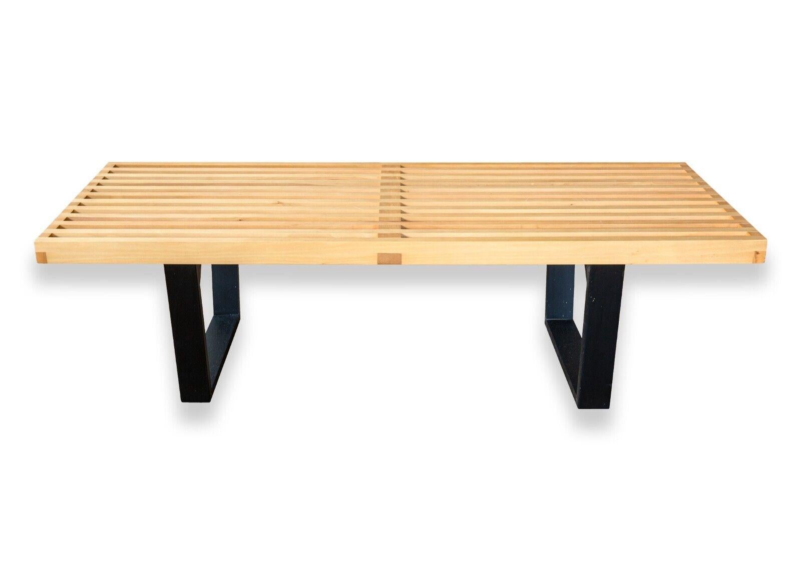 A mid century modern George Nelson for Herman Miller DWR slat bench. This is a gorgeous bench with fantastically simple design by George Nelson for Herman Miller. This bench features an all wood construction, a slatted maple wood seat, and two black