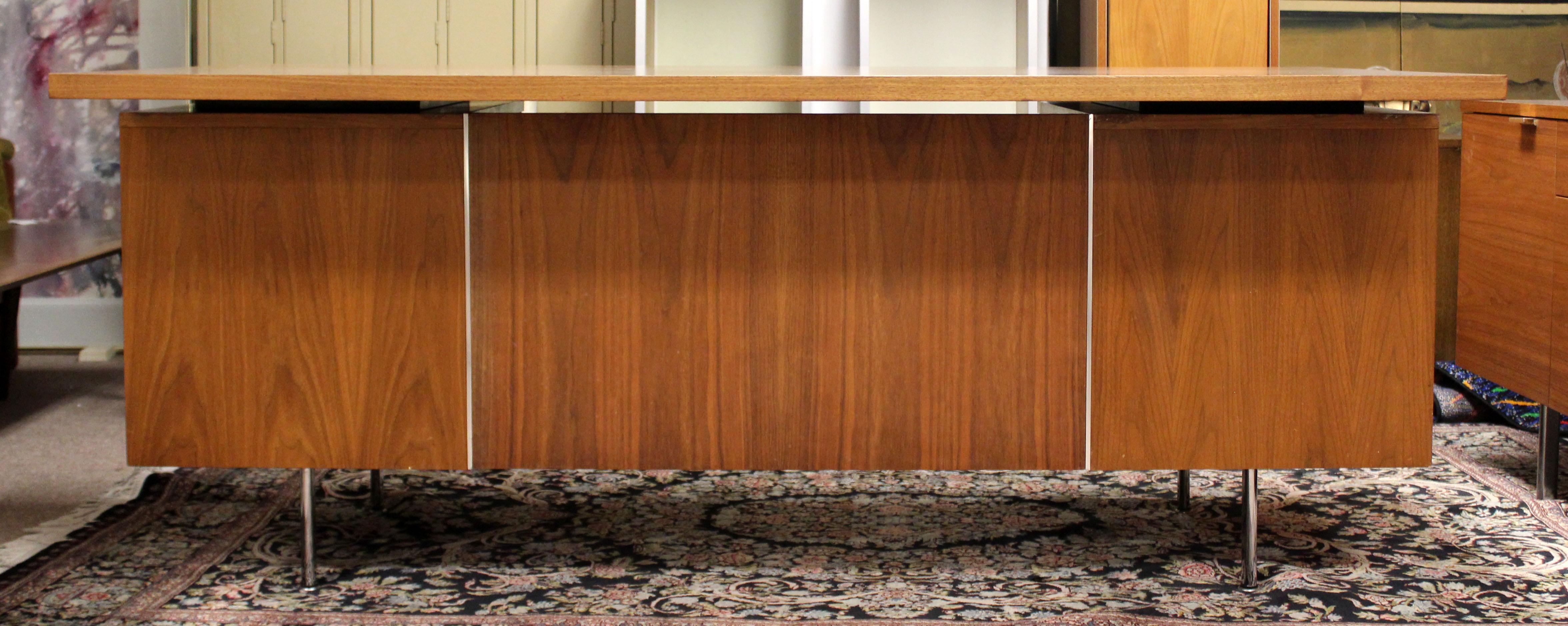 For your consideration are a wonderful credenza and executive desk, both made of walnut, by George Nelson for Herman Miller, circa 1950s. The desk has five drawers, and the credenza has four drawers and two shelves. The dimensions of the desk are