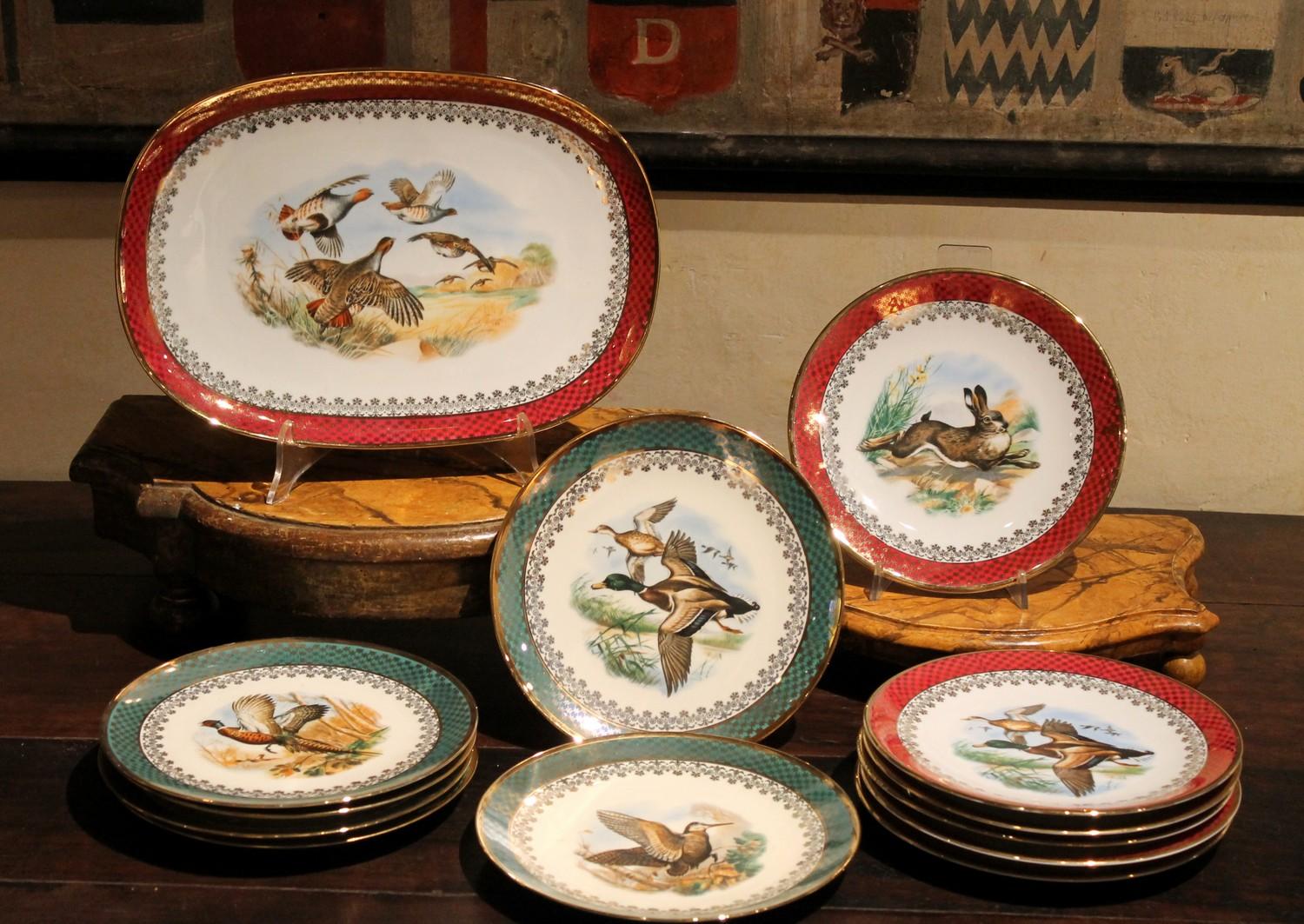 This charming Mid-Century Modern German porcelain serveware set is made up of 12 dishes and one platter, each with Bavaria Jaeger mark. 
Both the plates and the tray combine a sumptuous red or green border embellished with sparkling gilt decoration