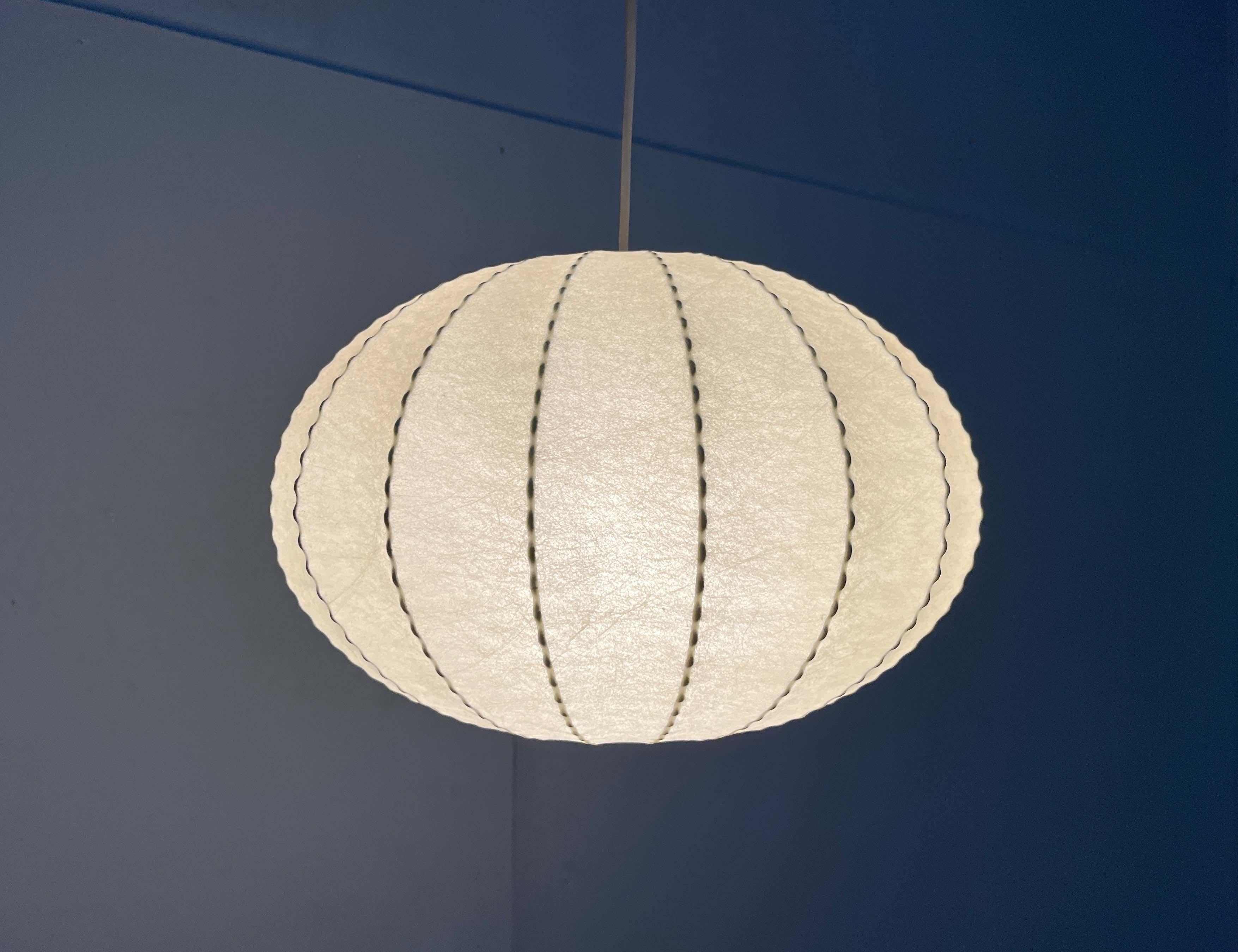 Lampada a sospensione Cocoon di Goldkant Leuchten, basata su un progetto degli anni '60 di Friedel Wauer.

Un design minimalista. La lampada ha la semplice forma di una sfera leggermente compressa. Il materiale Cocoon fornisce una luce diffusa e