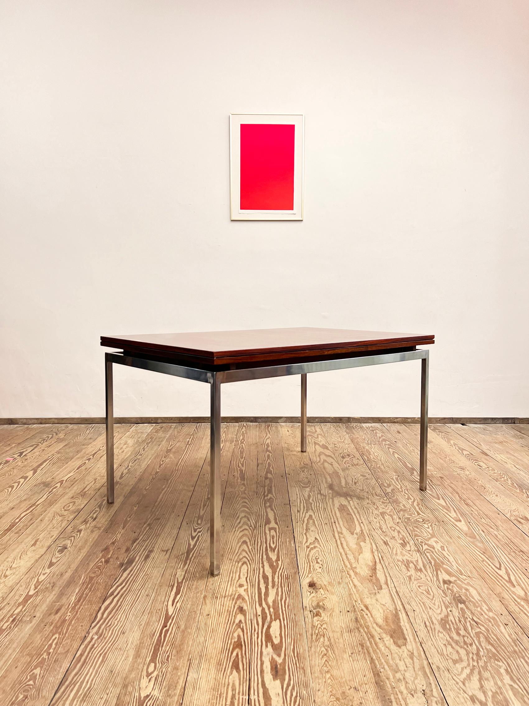Dimensions: 125 / 173 / 221 x 84,5 x 74 cm (Length / + extensions x Width x Height)

This large, elegant dining table is made out of rosewood veneer and was manufactured by Lübke in Germany. The table comes with two pull-out extensions and sits on