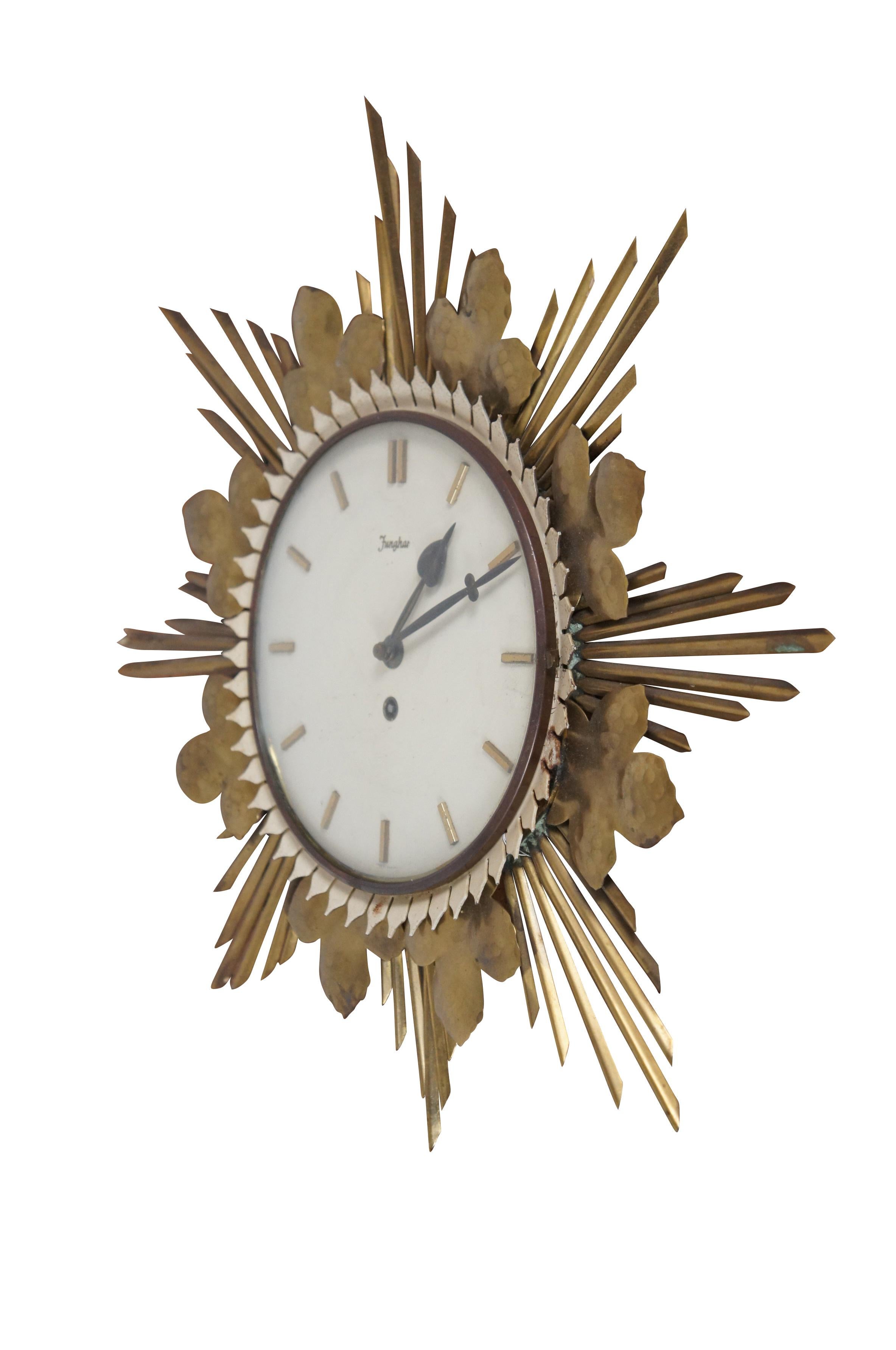 Mid 20th century Junghans key wound, wall hanging brass sunburst clock. Graduated rays accented with three-lobed hammered leaves; white painted face framed with small petals; numbered with raised brass pips; leaf shaped metal hands. Movement marked: