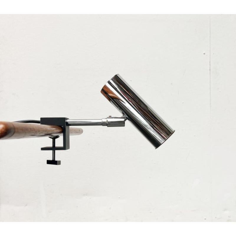 Minimalist clamp lamp from Cosack in chrome and black.

A simple and functional clip light. The cylindrical lamp head is connected to the shaft via a joint. The shaft ends in a cubic-shaped table clamp that is contrasted in black. A special detail