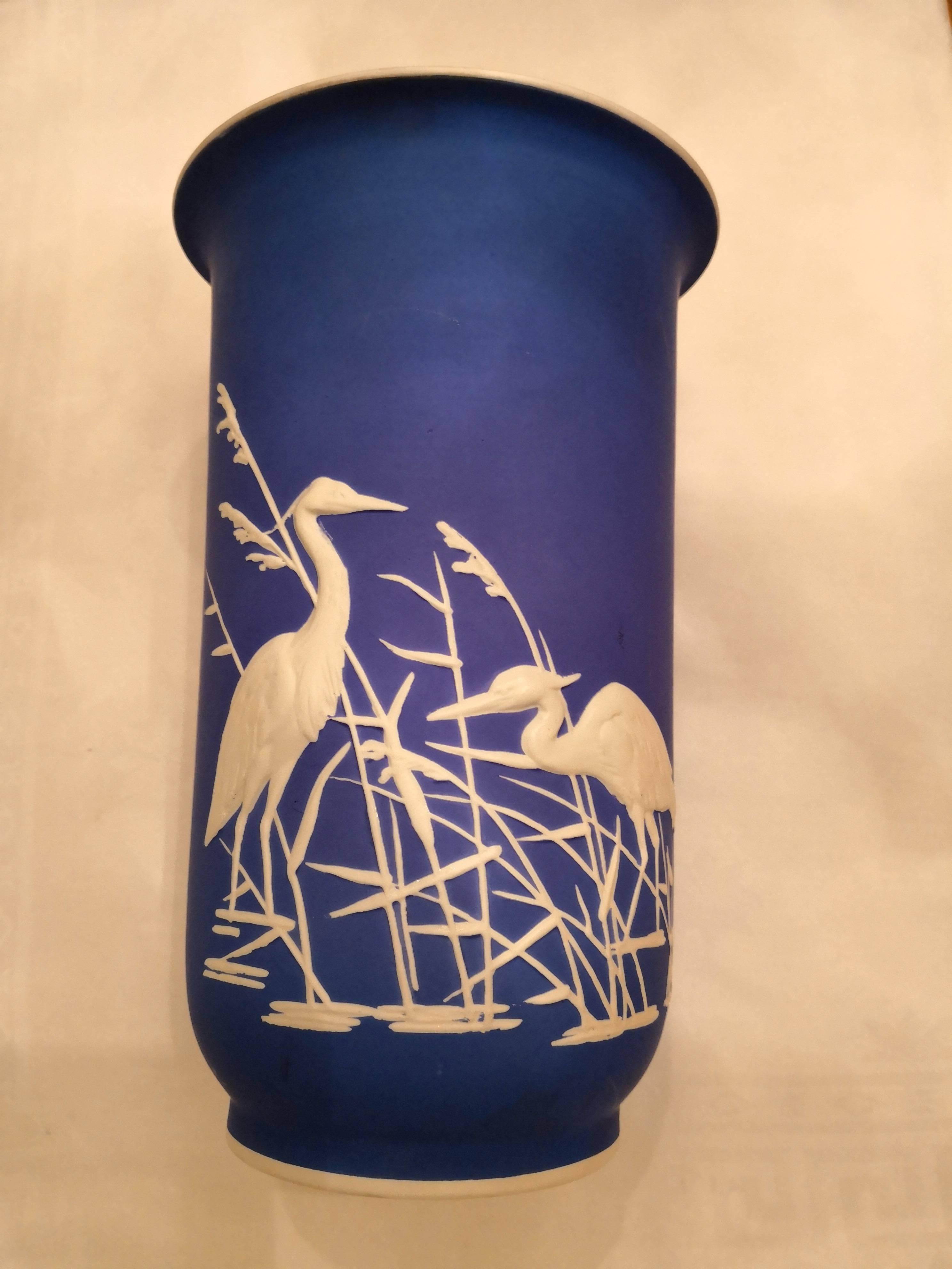 Straight vase from Rosenthal / Germany in bright cobalt blue with a decor in white. The decor shows a charmingscene with  sculptural crans and grasses in white. Outside unglazed porcelain and inside white glazed. On the bottom full hallmark from