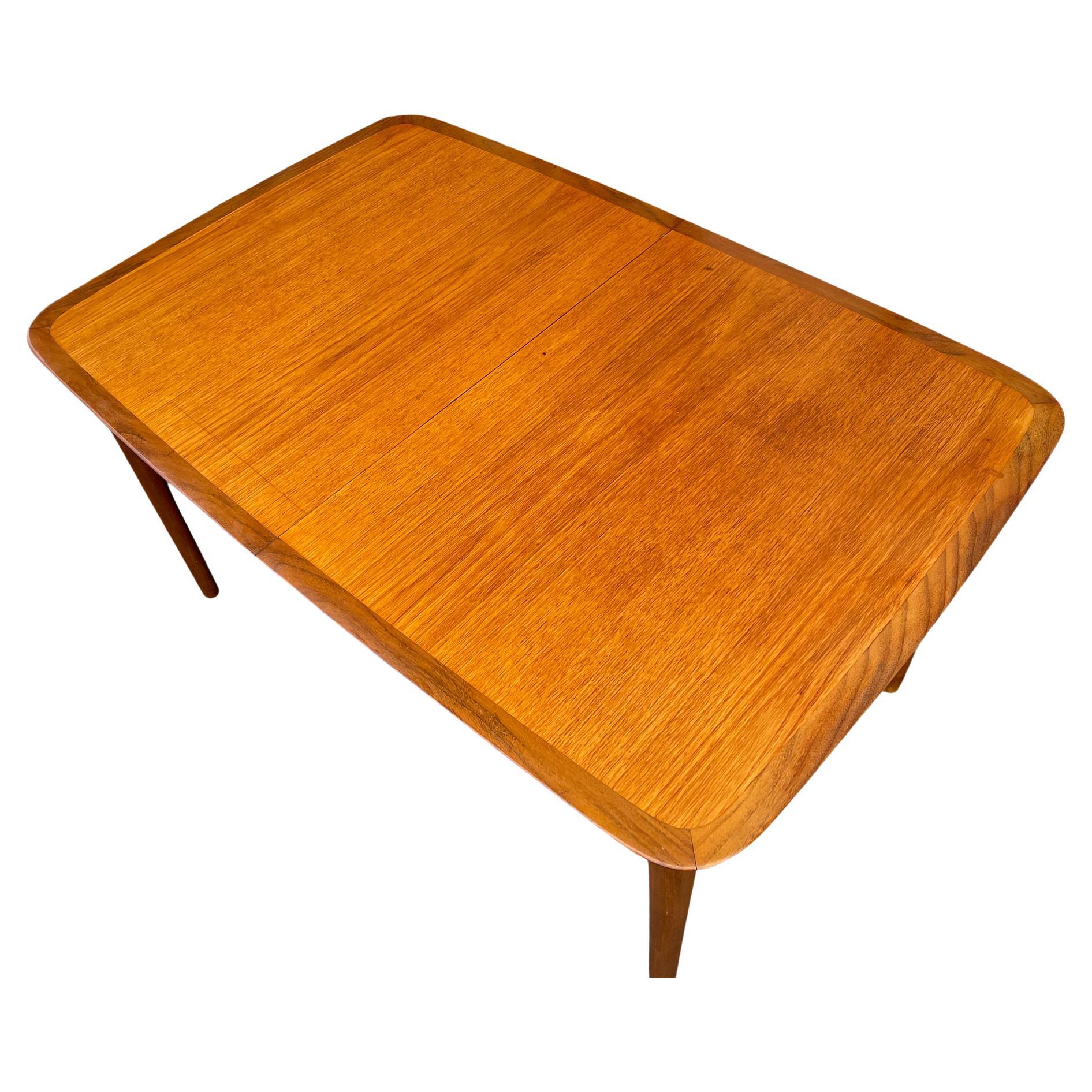 Mid-Century Modern German teak dining table with 4 leaves by LÜBKE. Very high quality Dining table with 4 Leaves that store underneath table. Beautiful Dining table design with rosewood edge details. 

Table measures 53.5