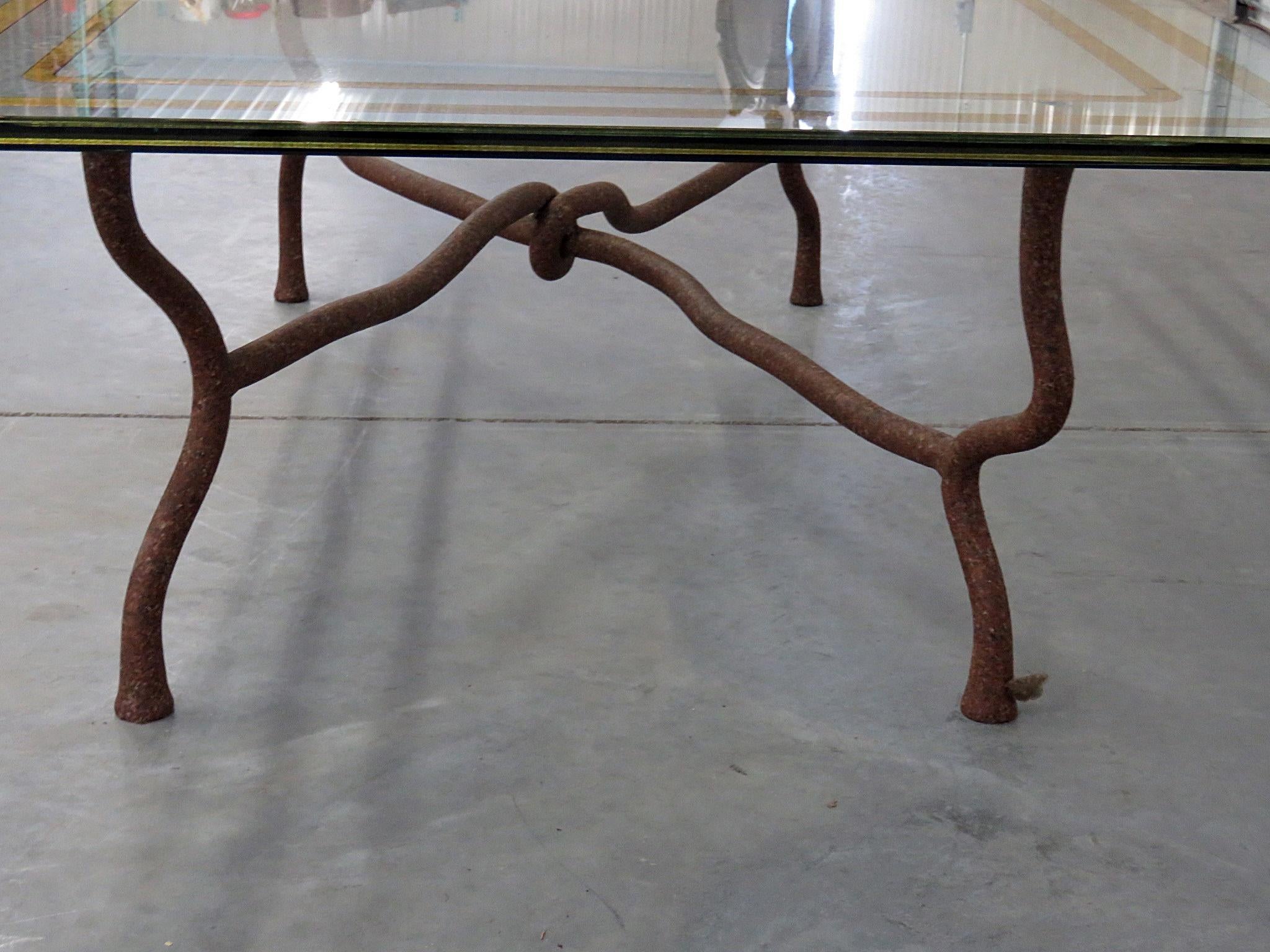 Mid-Century Modern Giacometti style glass top coffee table with metal inserts on a distressed metal base.