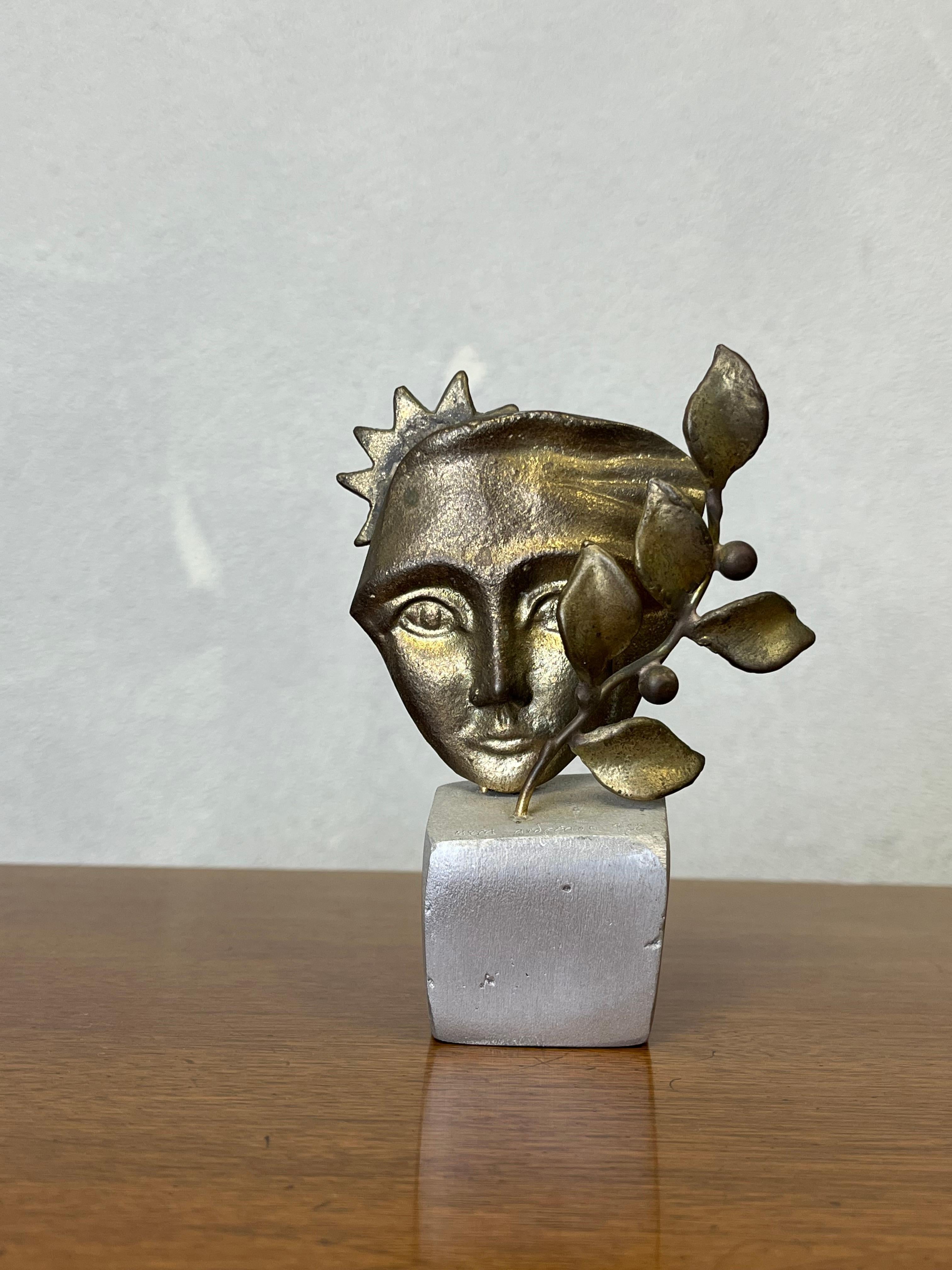 Einzigartige vergoldete Skulptur in der Art von Line Vautrin. Auf einem Würfel aus rostfreiem Metall sitzt das Gesicht einer Frau mit Flora und Sonne. versengt und nummeriert. 9/50. 