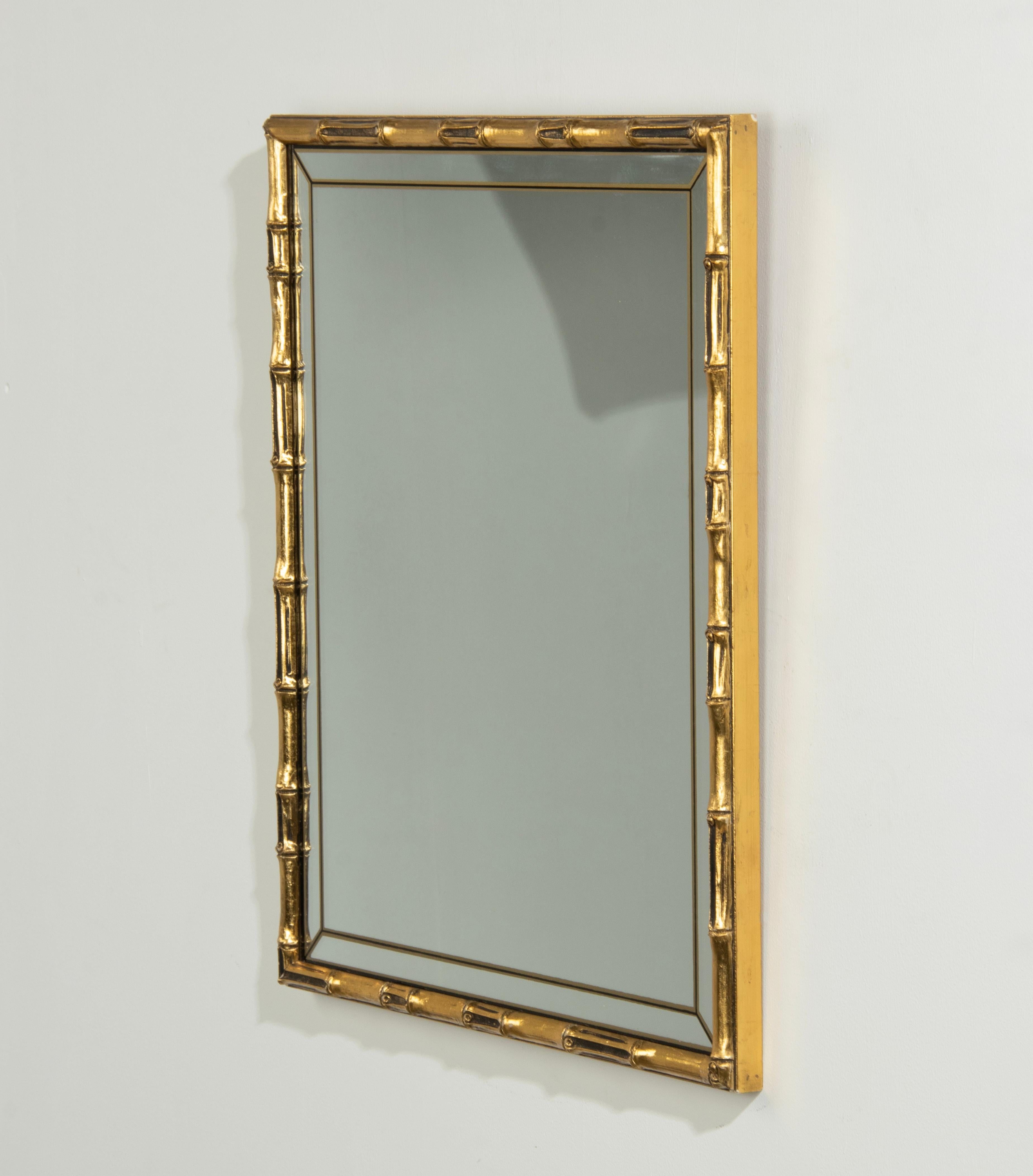 Ein eleganter Vergoldungsspiegel im Hollywood-Regency-Stil. Der Rahmen aus Bambusimitat ist aus geformtem Holz mit einer vergoldeten Patina. Das Spiegelglas hat ein dekoratives, abgeschrägtes Glas aus handbedrucktem Schwarz mit Goldstreifen.