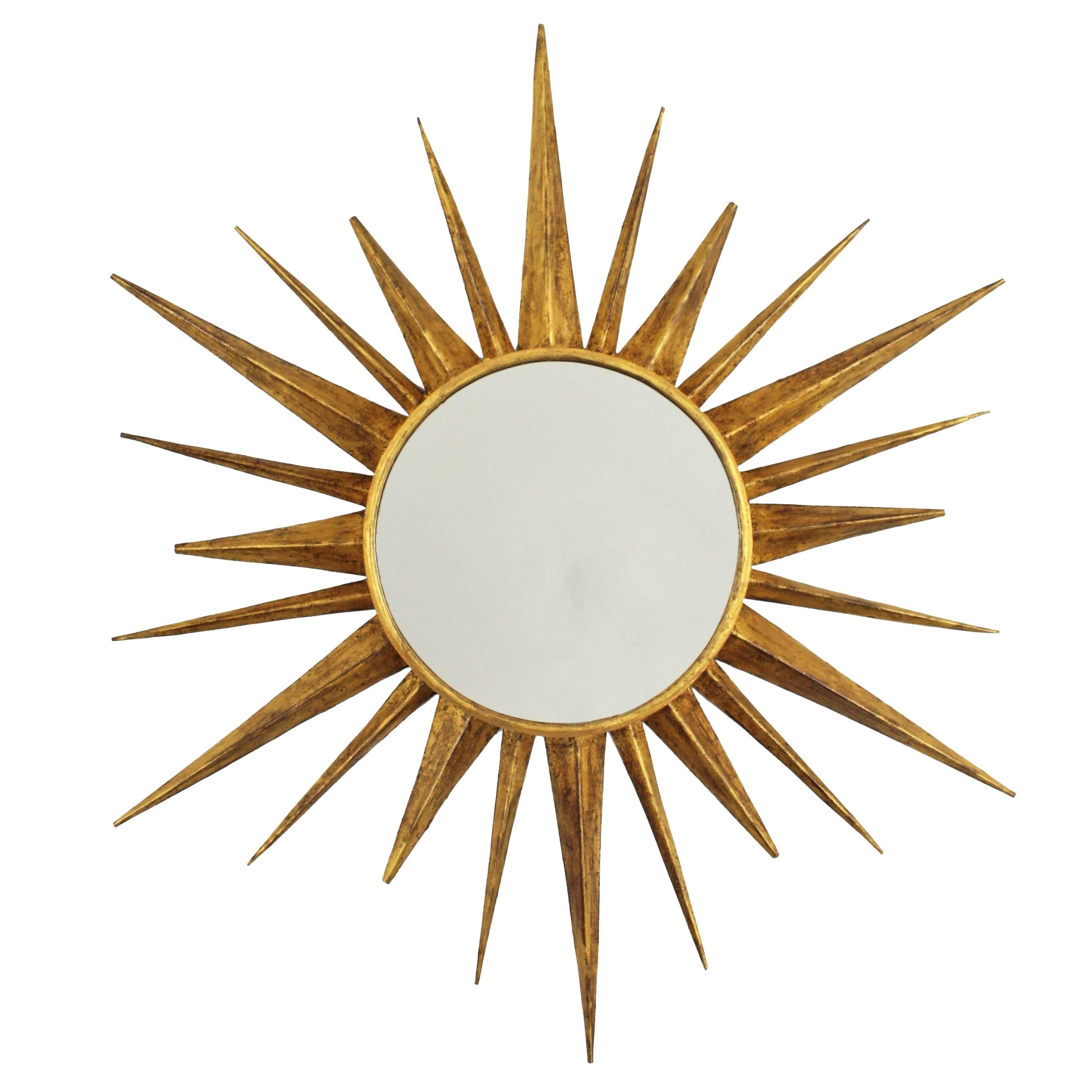 A highly decorative sunburst ceiling flush mount lamp that can be also a sunburst mirror. Hand-hammered iron with gold leaf finish and frosted glass , amber glass diffuser  or mirror in the centre. This piece can work also as a sunburst mirror (the