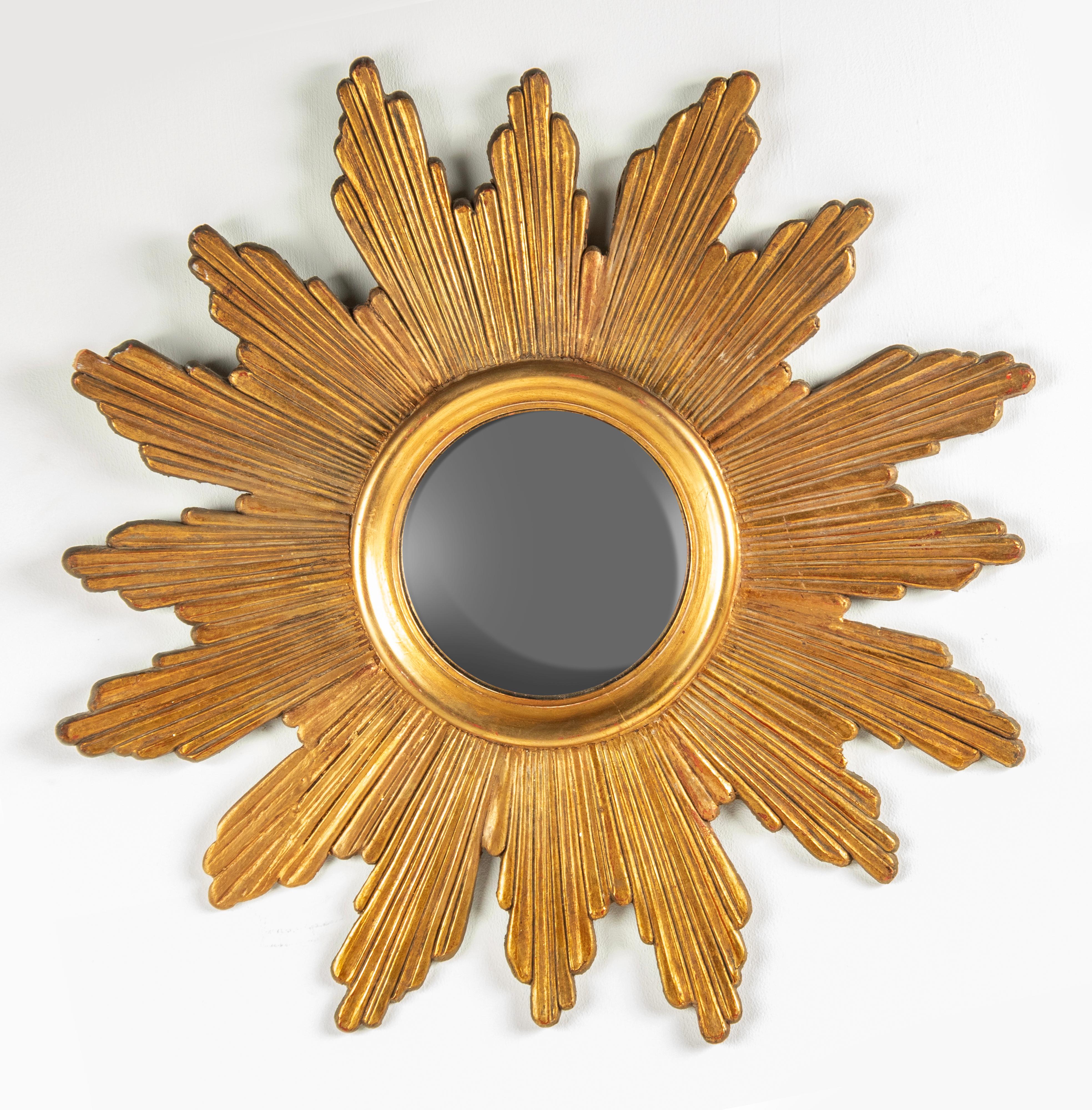Magnifique miroir en bois doré de style moderne du milieu du siècle. Le miroir est en bois sculpté à la main, avec une patine dorée. Avec miroir en verre convexe. Le bois et le verre sont en bon état. Une restauration sur un rayon, voir les deux