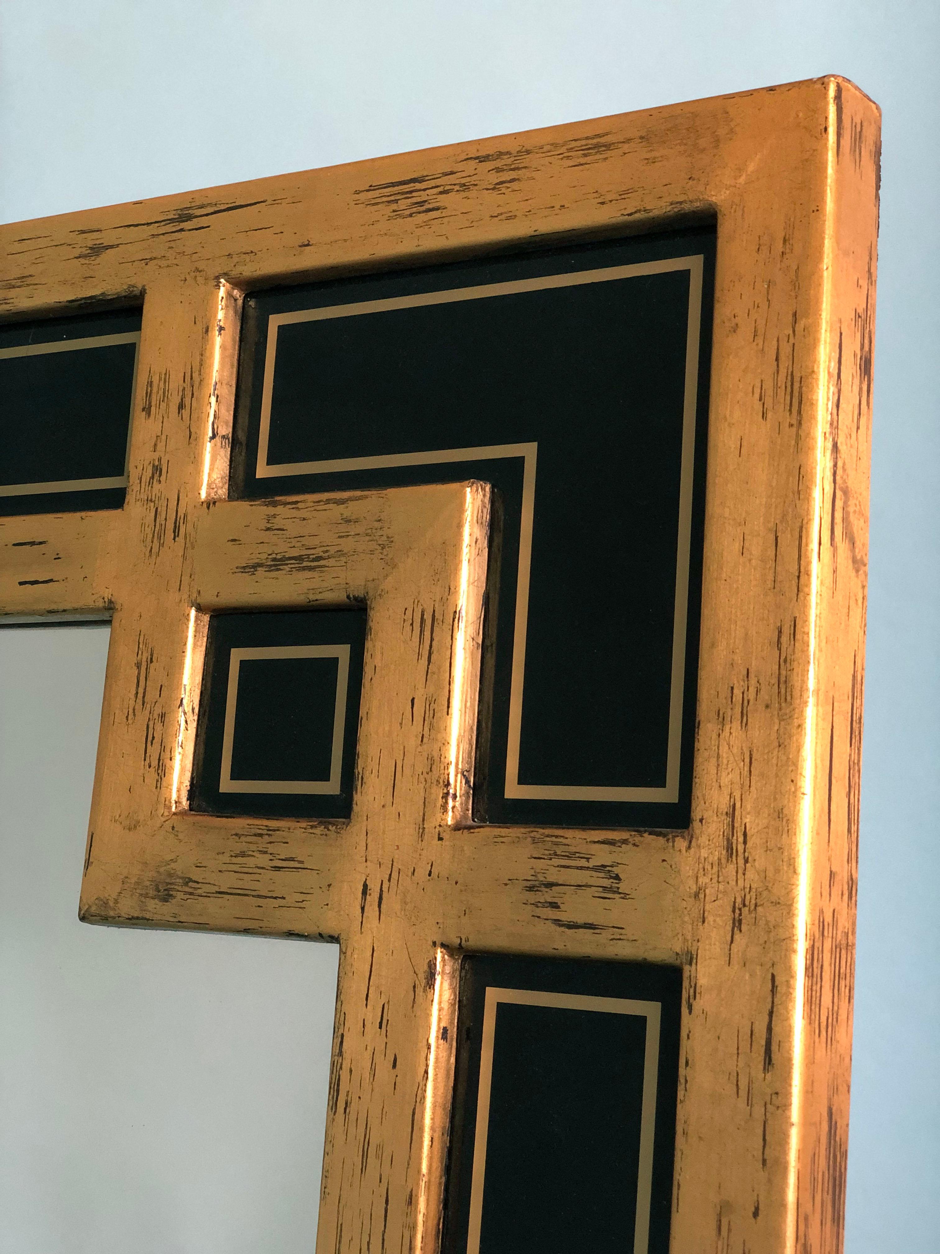 Großer Spiegel mit vergoldetem Holzrahmen in Mäanderform. Hergestellt in Belgien von Deknudt in den 1970er Jahren. Mit eingefügten schwarzen Glasplatten, die das Design vervollständigen.

Wunderschön verwitterter Spiegel In sehr gutem Zustand.