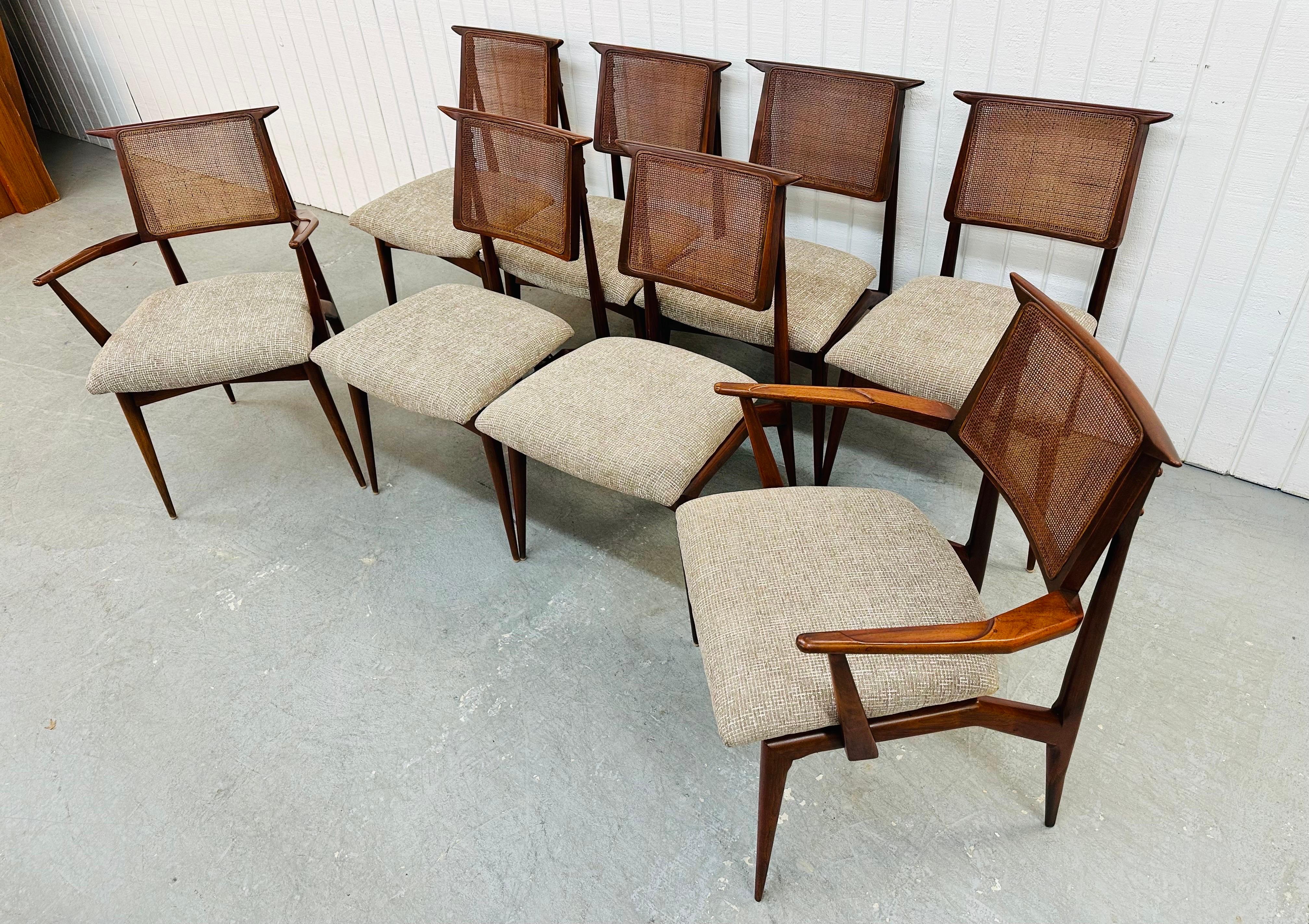 This listing is for a set of Mid-Century Modern Gio Ponti Style Walnut Dining Chairs. Featuring six straight chairs, two arm chairs, cane back rests, and newly upholstered gray seats. This is an exceptional combination of quality and design in the