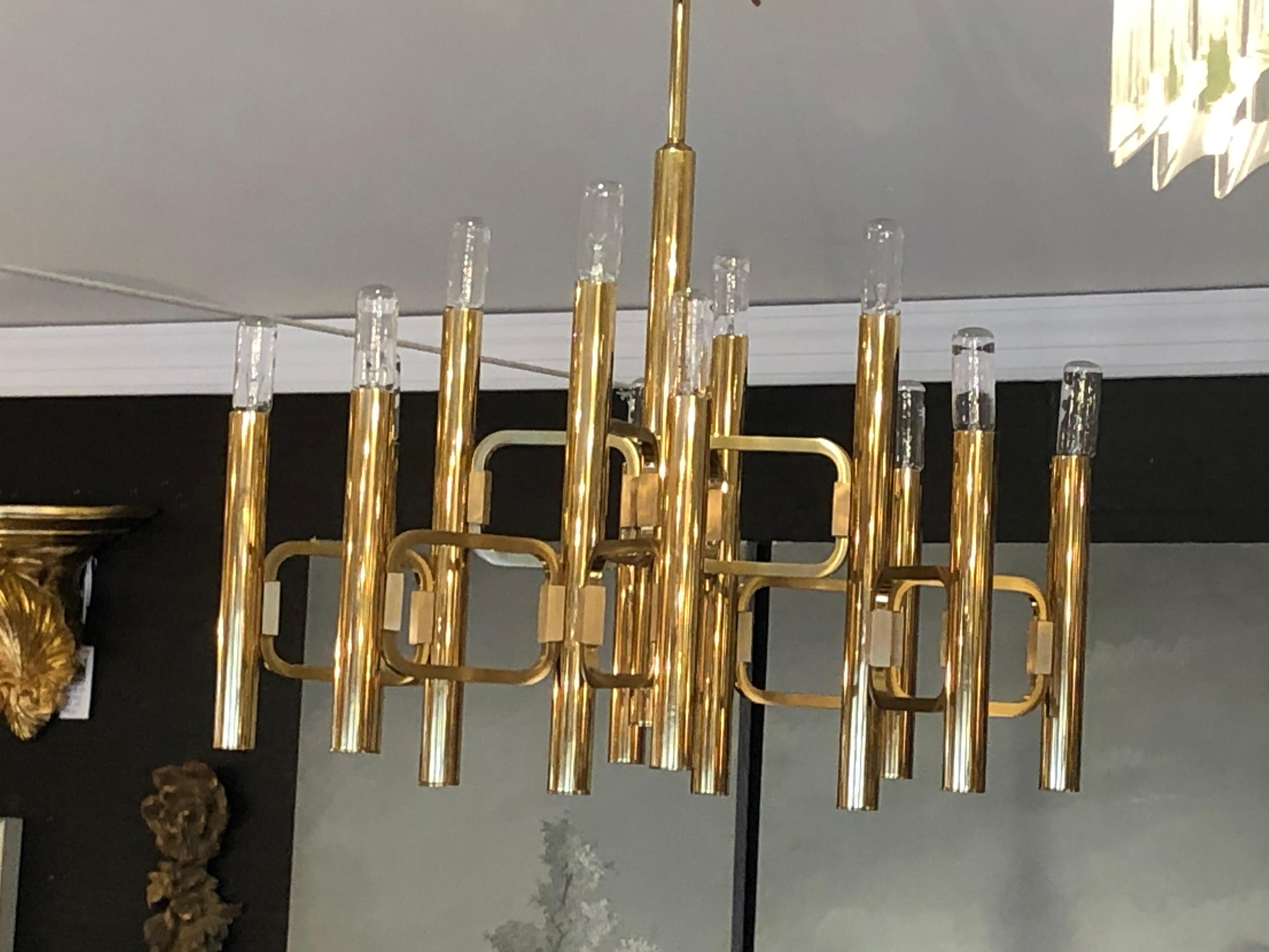 A fabulous very difficult to find mid century modern gold-plated chandelier from the Modulo Collection,  produced by Profili Industria Lampadari Spa. The bulbs are elongated, almost tube formed. When illuminated the entire piece glistens. Made in