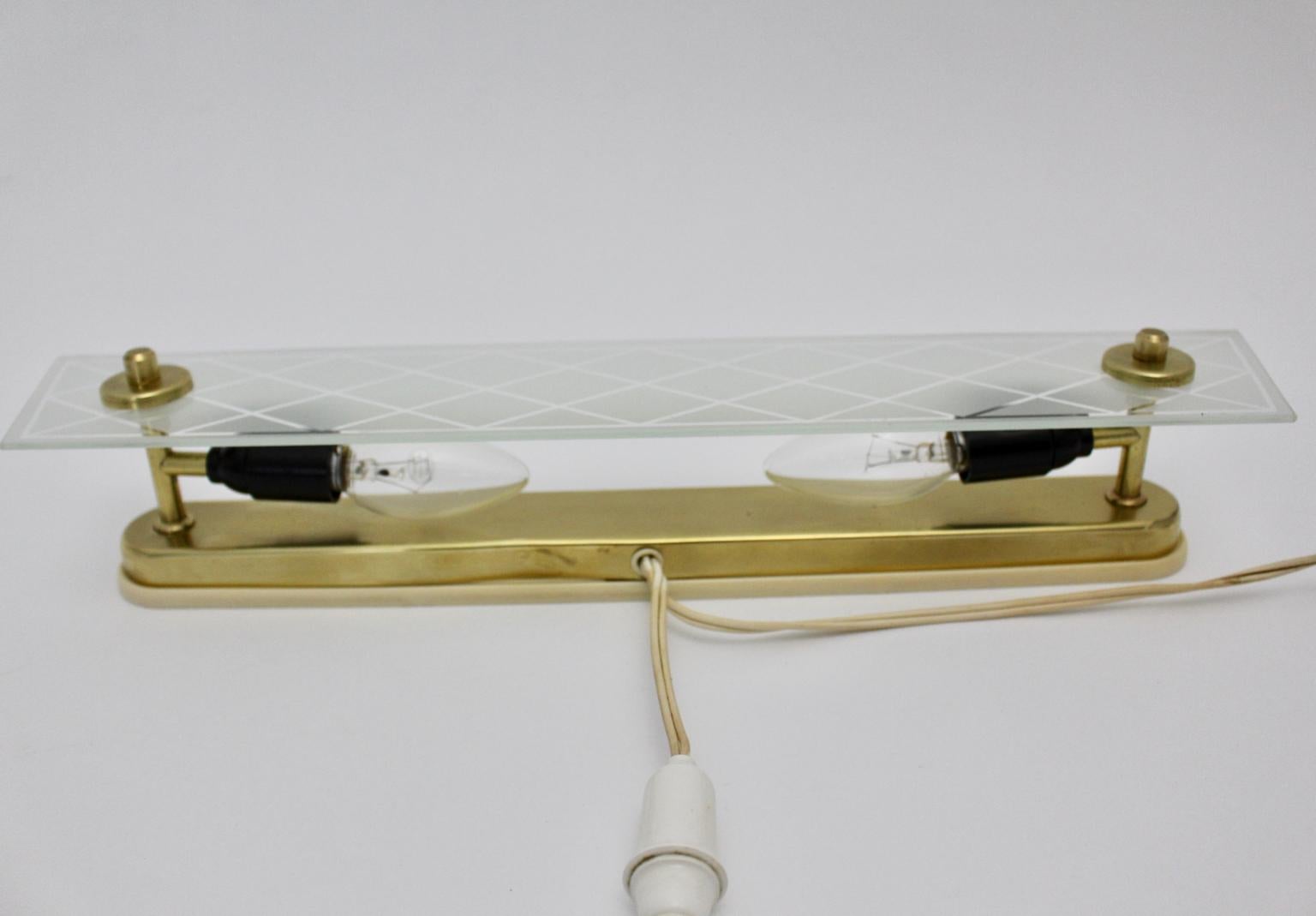 Mid Century Modern vintage amazing brass and glass sconce designed and executed in Italy, 1950.
The wall light features a glass front with etched rhombus pattern and also brass details and a brass fixture.
The original condition is very good with