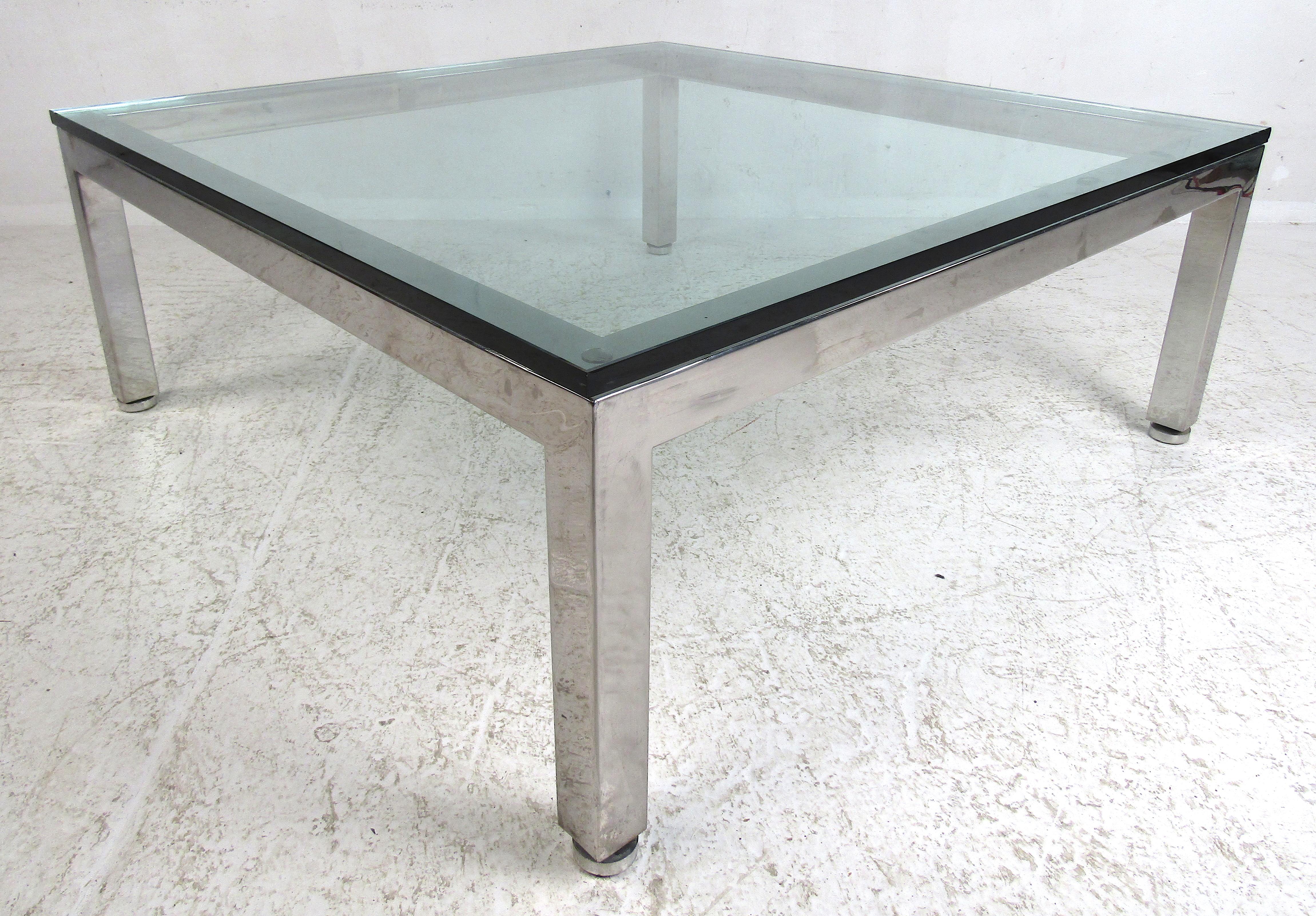 This beautiful vintage square coffee table features a very thick glass top with slightly beveled edges. Sleek design with circular adjustable feet and a heavy chrome frame. This elegant Milo Baughman style cocktail table makes the perfect addition