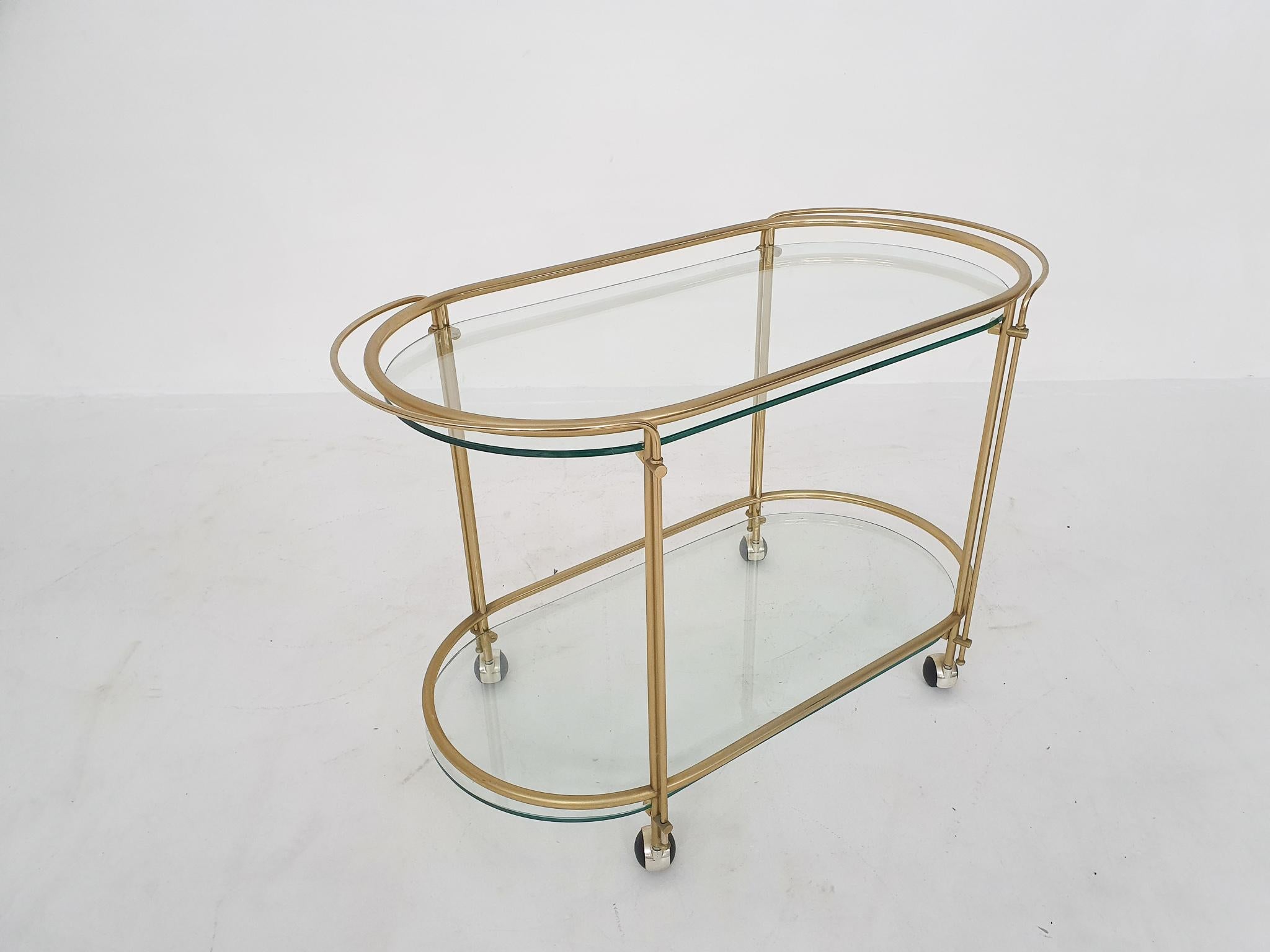 Gold metal bar cart with glass shelves. The upper handle is extendable.
In good condition.