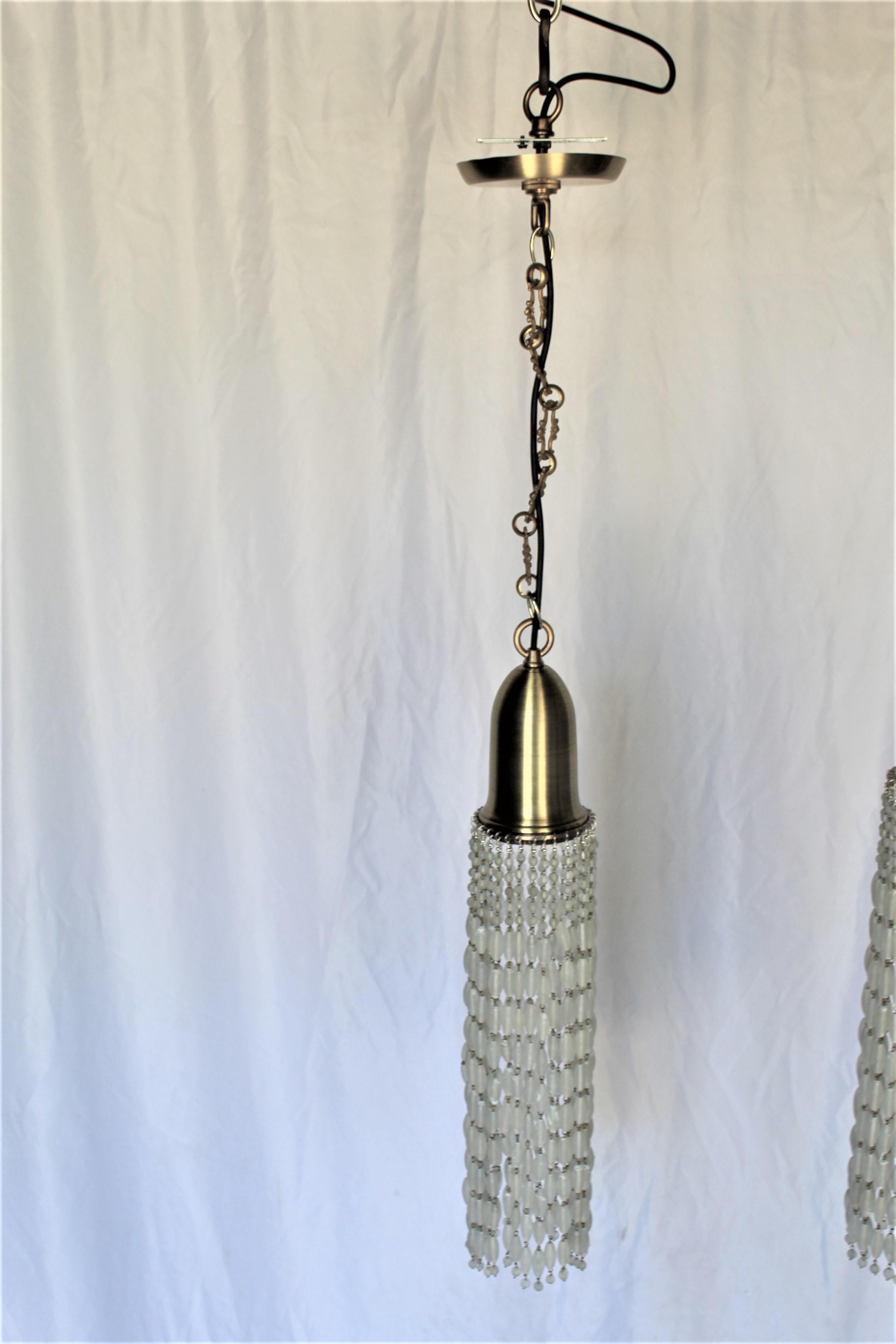 A pair of custom designed and made of solid brass and bronze metal. Shade is in the shape of a bell in spun satin finished brass and is 5 1/2