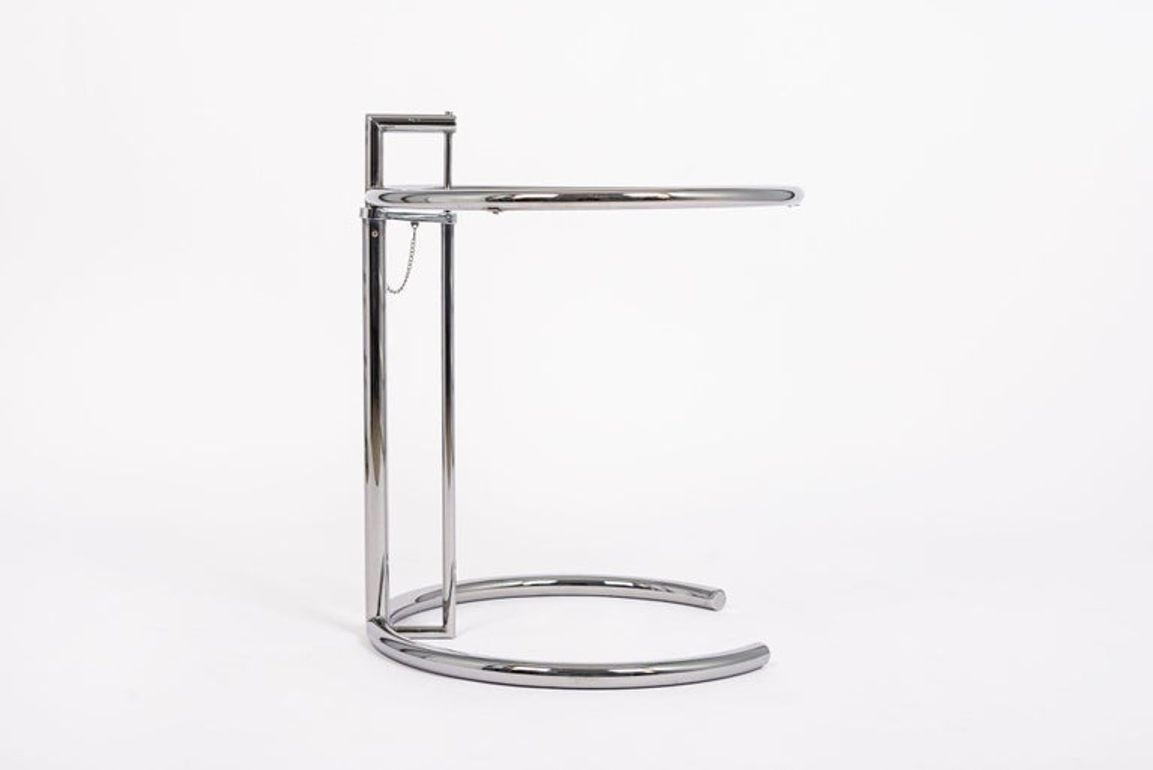 Cette table d'appoint en acier tubulaire et en verre Eileen Gray (attribuée) E1027 a été conçue à l'origine par Gray en 1926. Le design ingénieux se compose d'un cadre en acier tubulaire chromé et d'un plateau de table circulaire en verre qui
