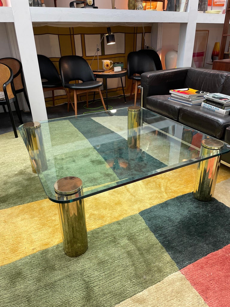 Vintage modern glass coffee table with beautiful detailed brass legs in the style of Karl Springer and similar to Pace Collection.