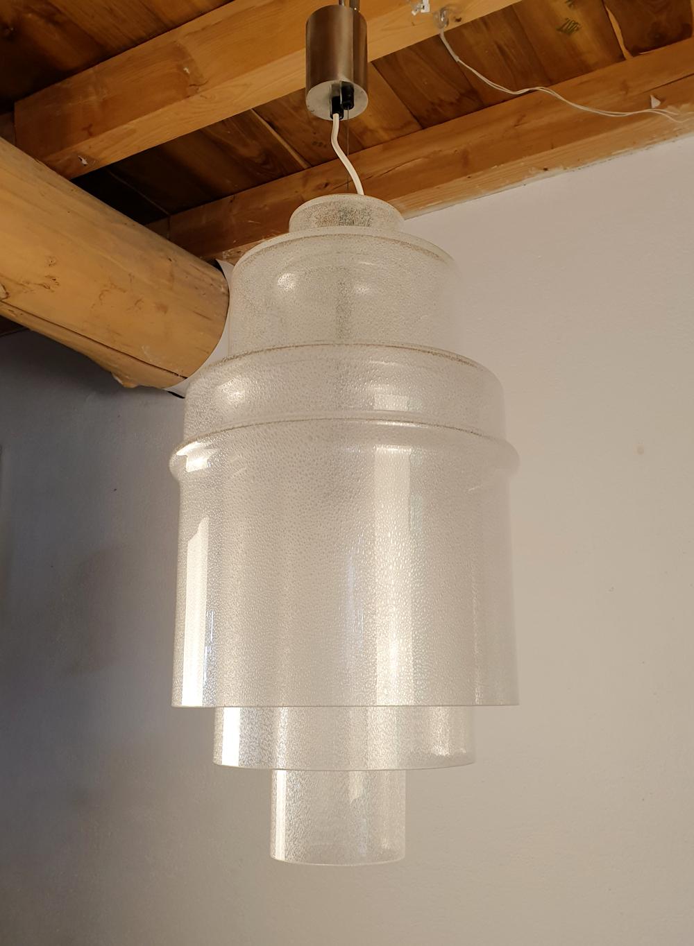 Geometric shape and transparency for this Murano glass Mid-Century Modern pendant chandelier, by Carlo Nason for Mazzega, Italy 1970s.
The vintage chandelier is made of three clear Murano glass pieces, with multiple small air bubbles inside the