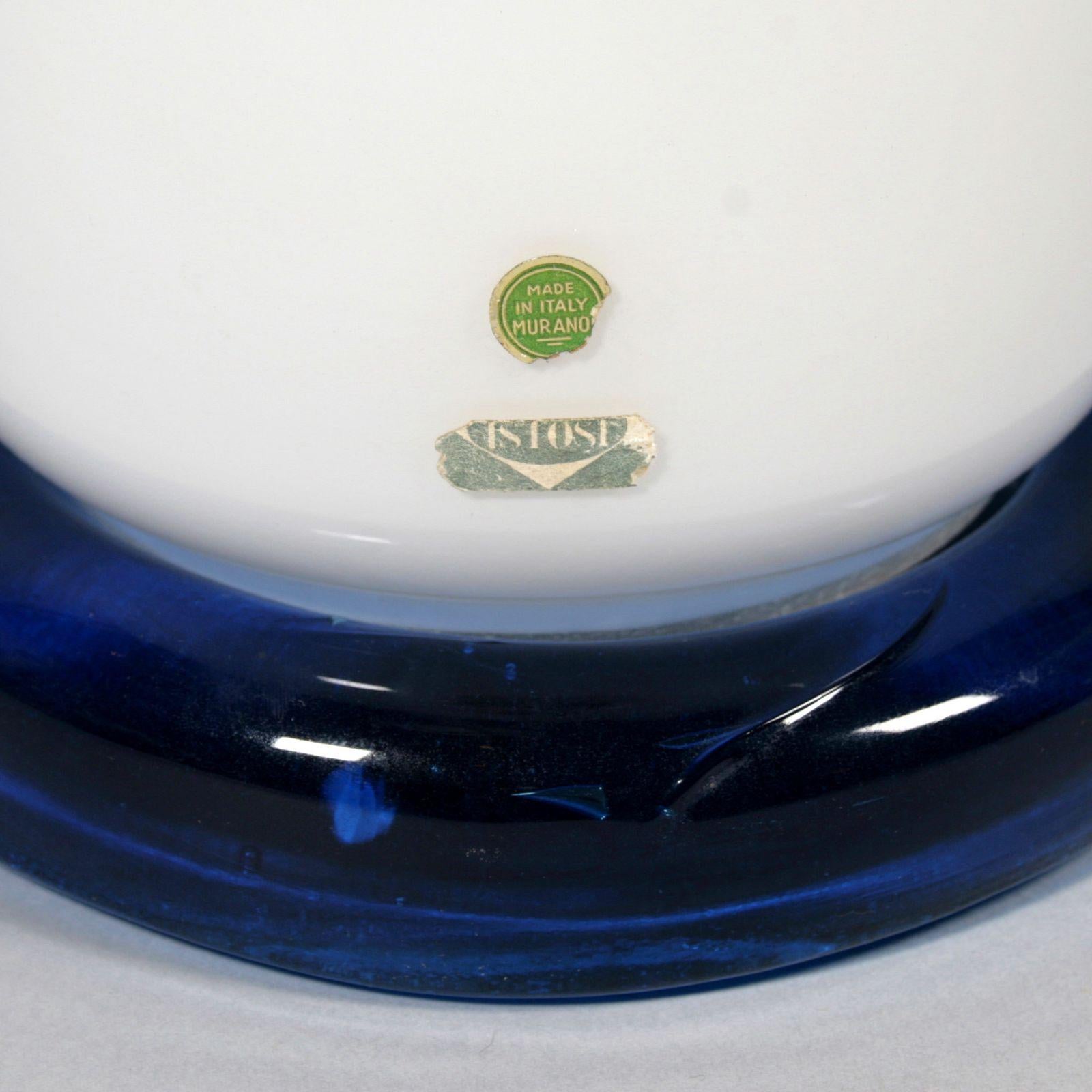 Rara lámpara de sobremesa grande de cristal con detalles decorativos inusuales. La etiqueta de cristal original de Vistosi está en la base. La parte superior se levanta de la base de cristal azul para cambiar la bombilla. Una pieza escultórica