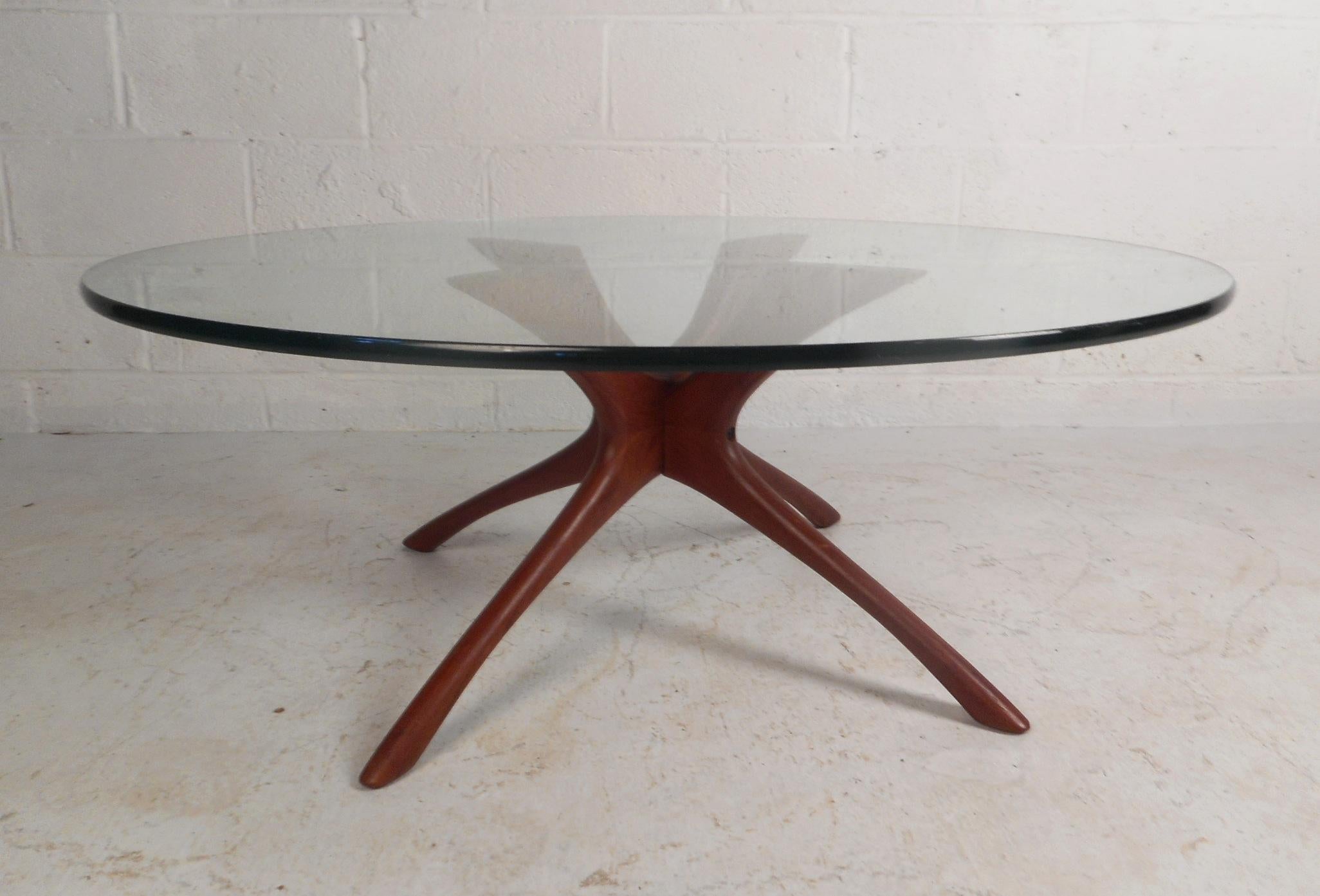 This gorgeous vintage modern cocktail table features a thick round glass top and a sculpted walnut base. A sleek and sturdy design by Adrian Pearsall that is sure to make a lasting impression in any modern interior. Please confirm item location (NY