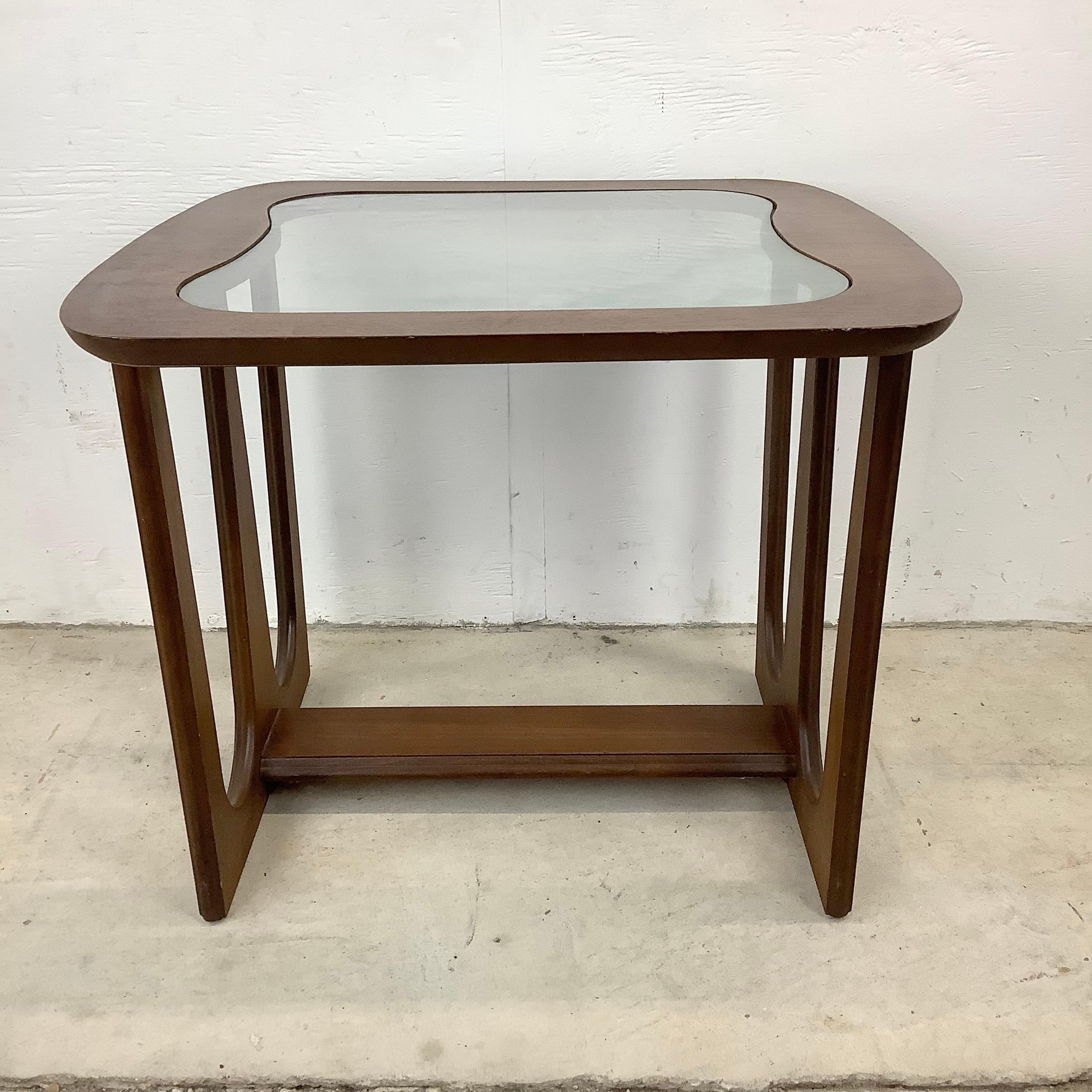Simple yet stylish mid-century modern side table features a striking sculptural wood base with a rounded edge glass top. Perfect end table as a seating side table or lamp table, adding vintage modern style in a subtle mcm package.

Dimensions: 24w