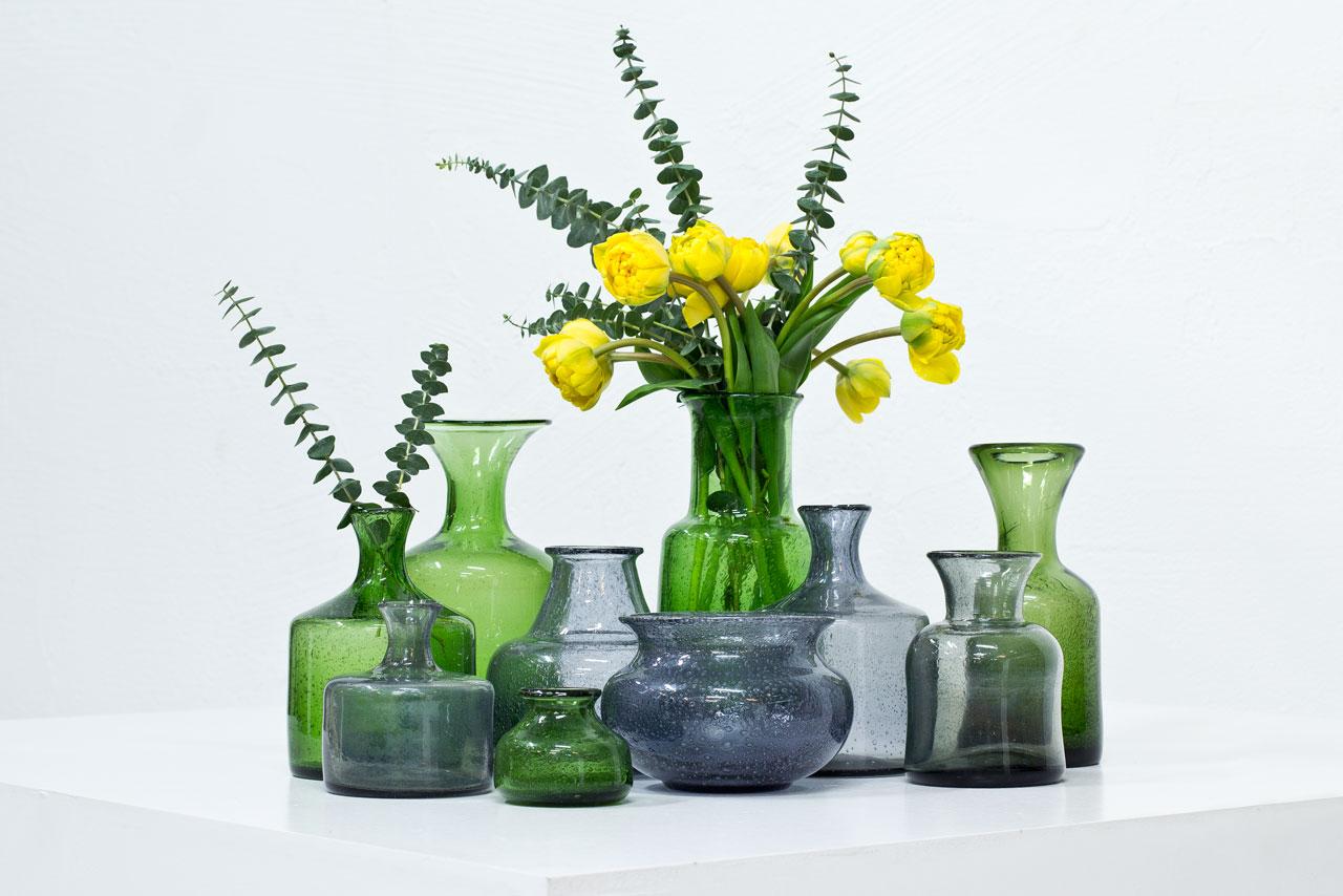 Group of ten glass vases designed by Erik Höglund, mouth blown at Boda glass factory in Sweden during the 1950s. Collection of grey and green vases of various sizes and shapes, all with bubbles in the glass. All engraved.
